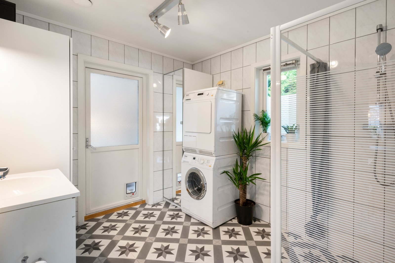 Badet har servant, dusjhjørne, kloset og opplegg for vaskemaskin/tørketrommel Galleribilde