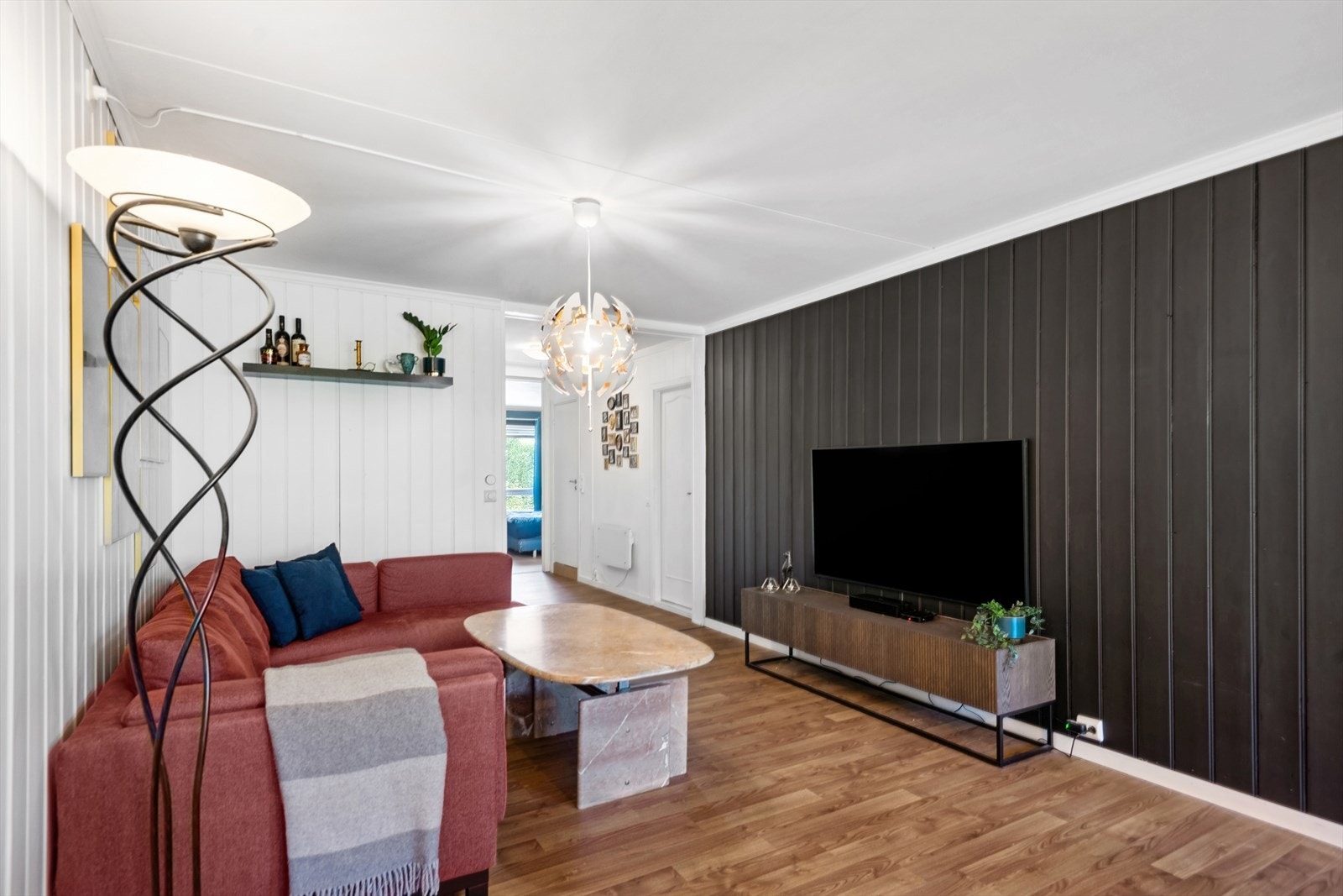 Stuen har en kontrast vegg i mørk farge som er lekker og gir et godt inntrykk av boligen. Galleribilde