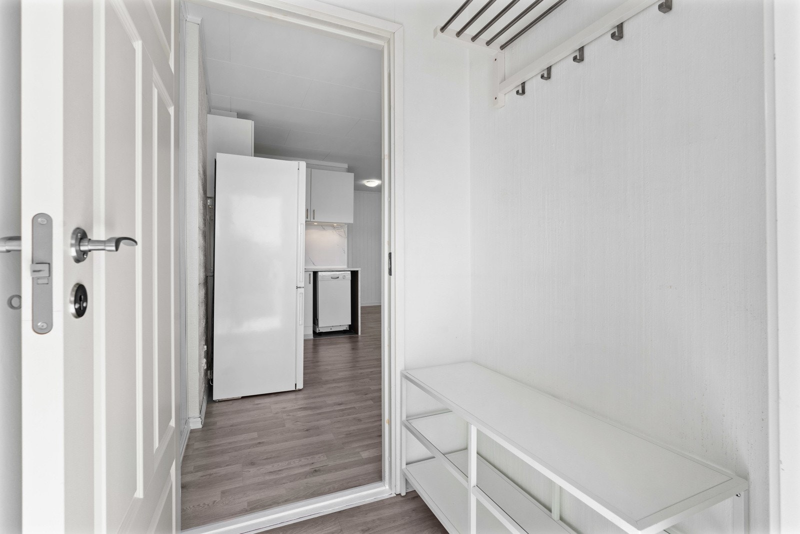 Hyggelig vindfang med plass til oppbevaring av ytterbekledningen din. Lyse fargevalg som også er gjennomgående for resten av boligen - velkommen inn! Galleribilde