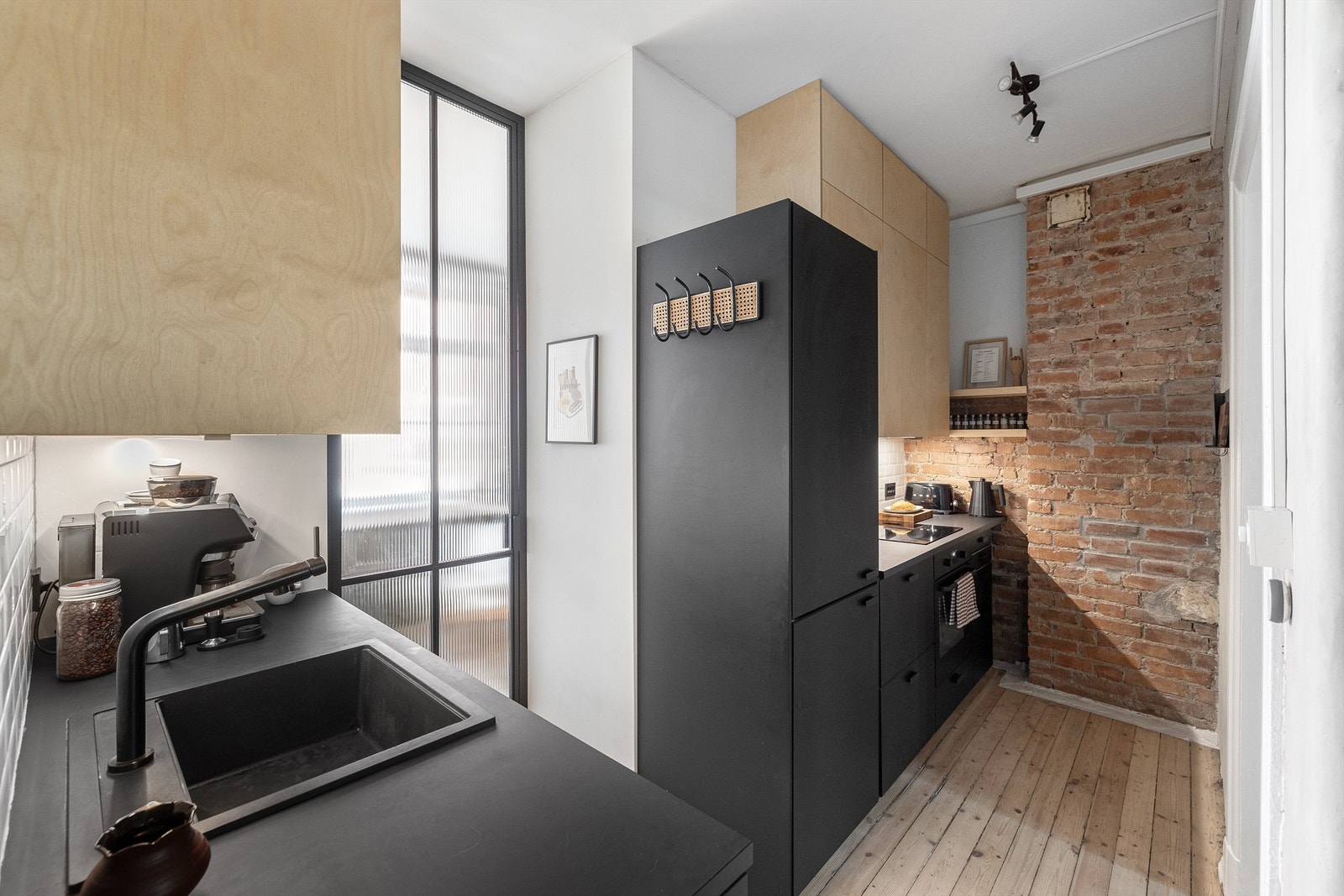 Smart og lekkert kjøkken som utnytter den gode takhøyden til maksimal lagringsplass Galleribilde