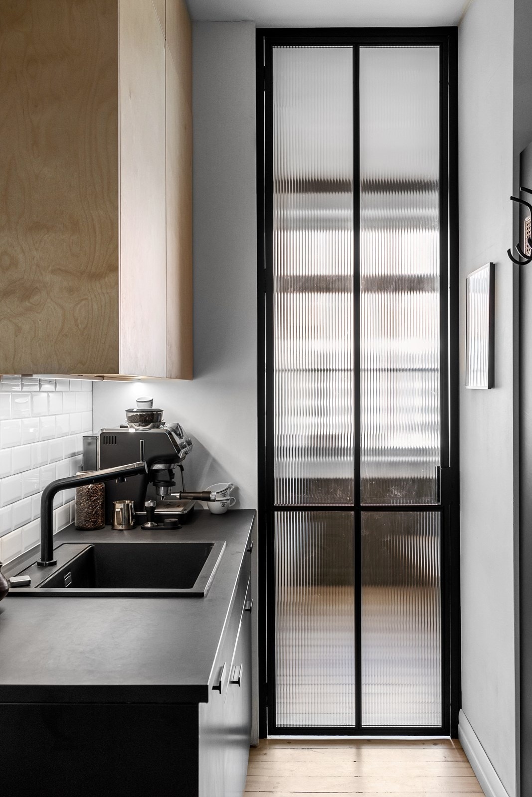 Kjøkkenet og soverommet er adskilt med en spesiallaget smijernsdør med rillet glass Galleribilde