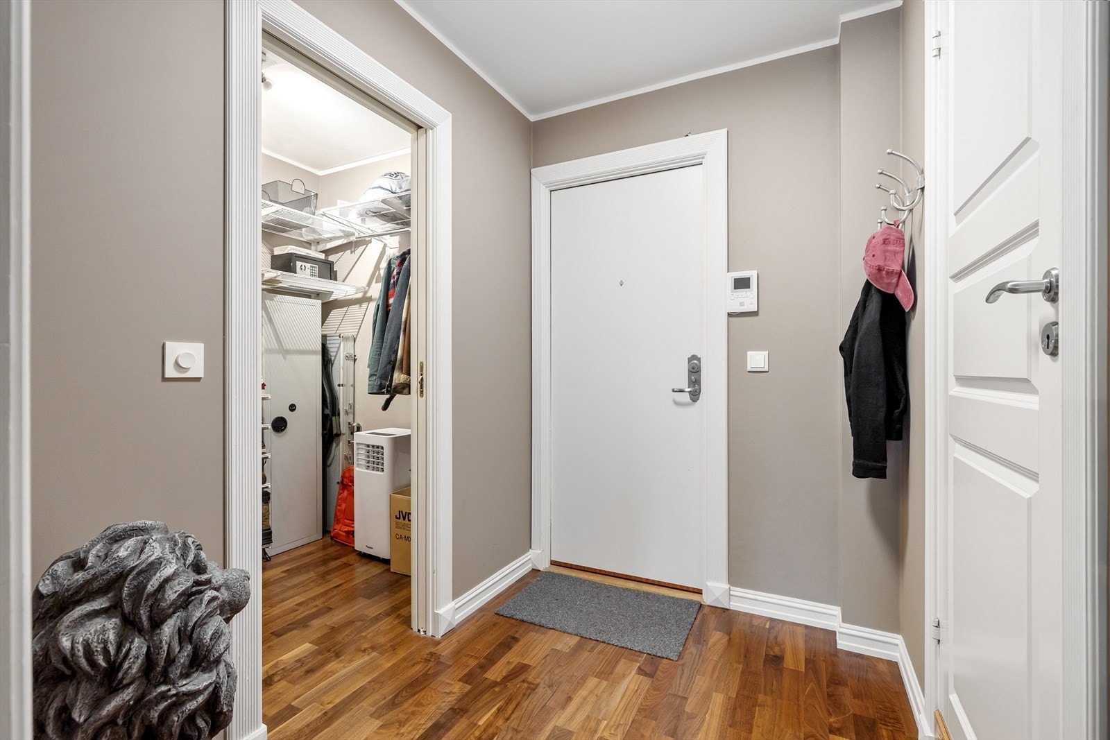 Entreen gir et pent førsteinntrykk og har nøttefarget parkettgulv og malte vegger i en lun sandfarge. Galleribilde