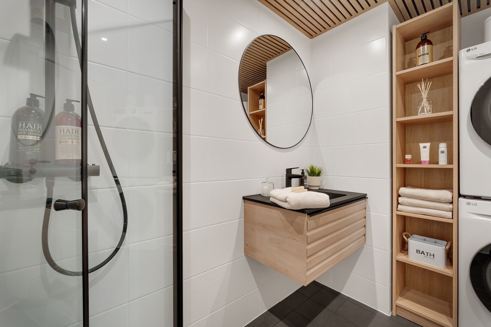 Badet er innredet med benkeskap med servant og dusjdør Galleribilde