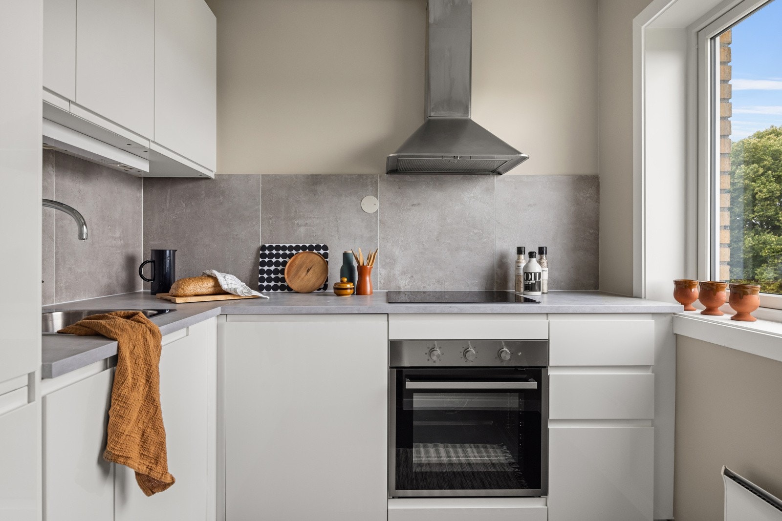 Tidsriktig glatt innredning fra 2018 med integrerte grep, soft close, armatur, laminat benkeplate med nedfelt stålkum og keramisk topp, integrert komfyr, oppvaskmaskin, kjøl/frys. Galleribilde