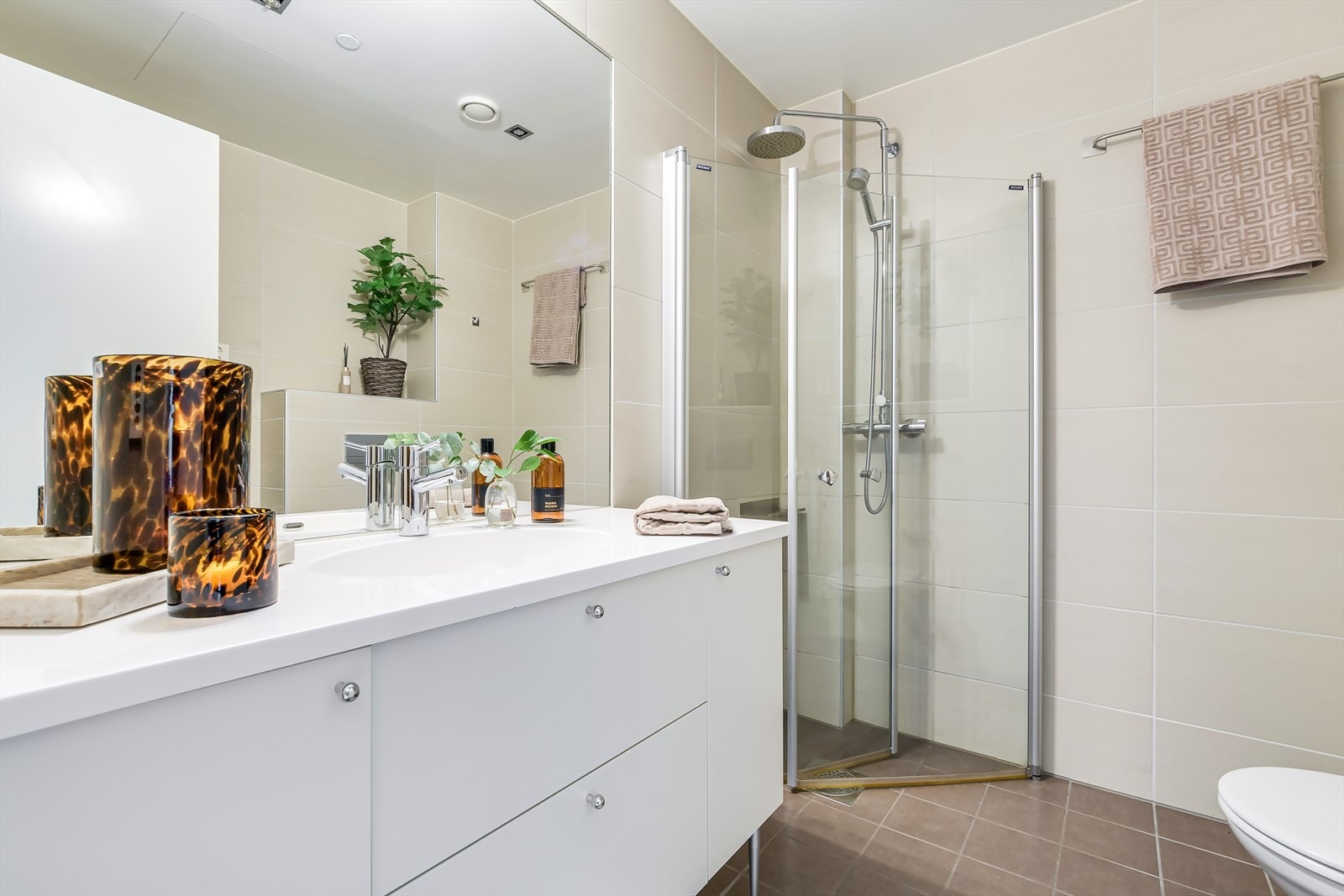 Dette delikate og plassbygde badet er flislagt med materialer av høy kvalitet og har en moderne utforming. Galleribilde