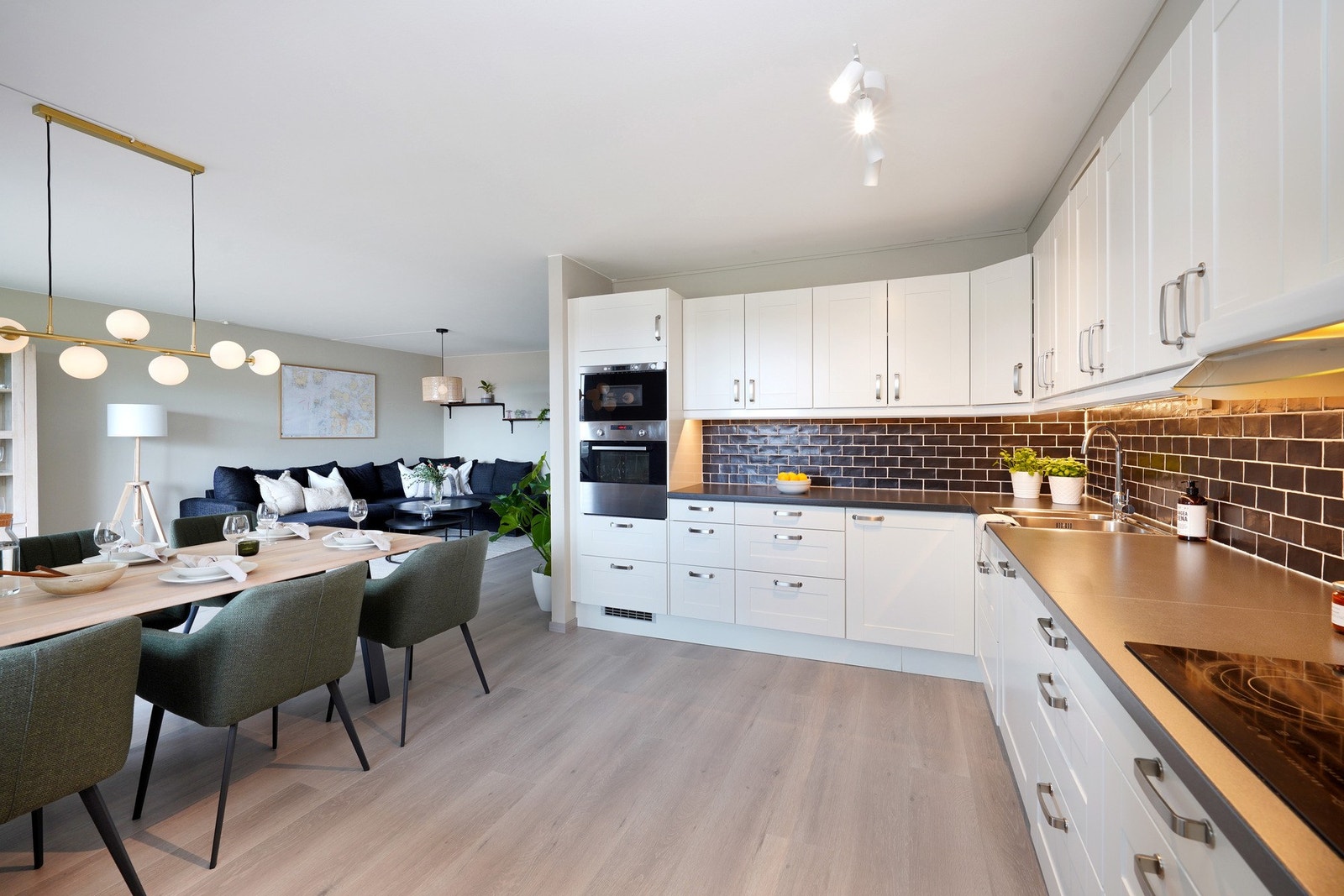 Kjøkkenet har integrerte hvitevarer som platetopp, oppvaskmaskin, stekeovn og mikro Galleribilde