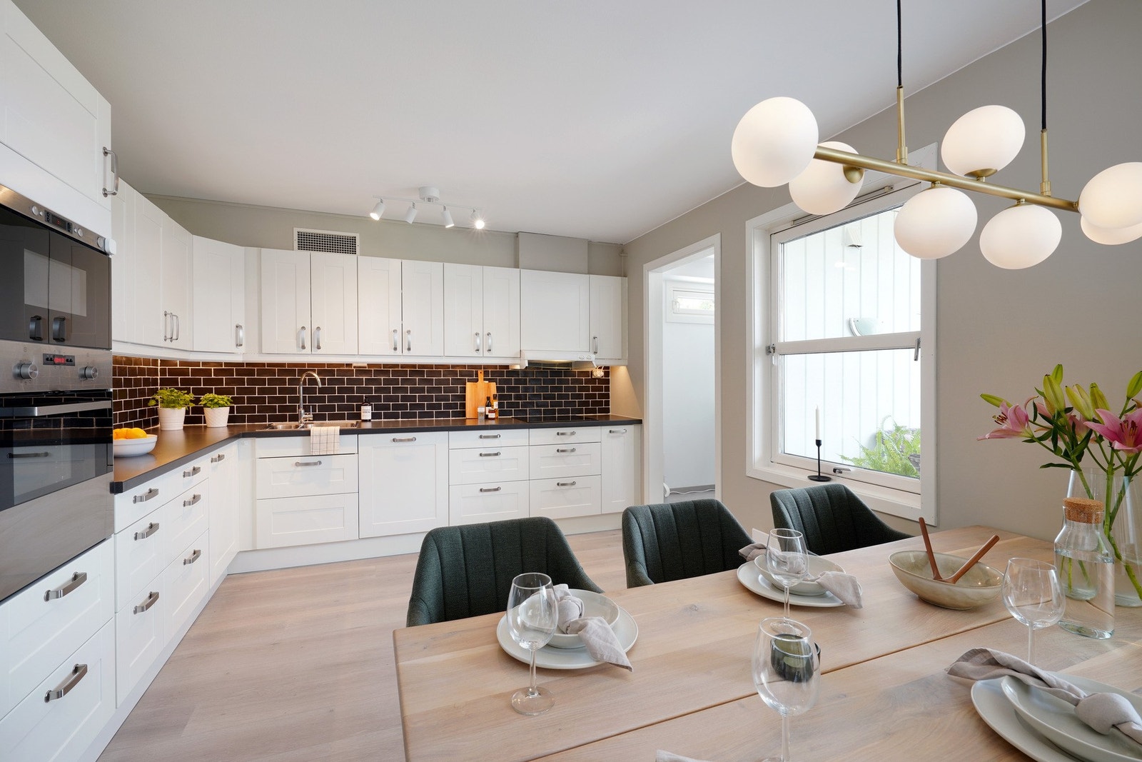 Tidløst kjøkken i hvit utførelse, med bod der en kan ha oppbevaring Galleribilde