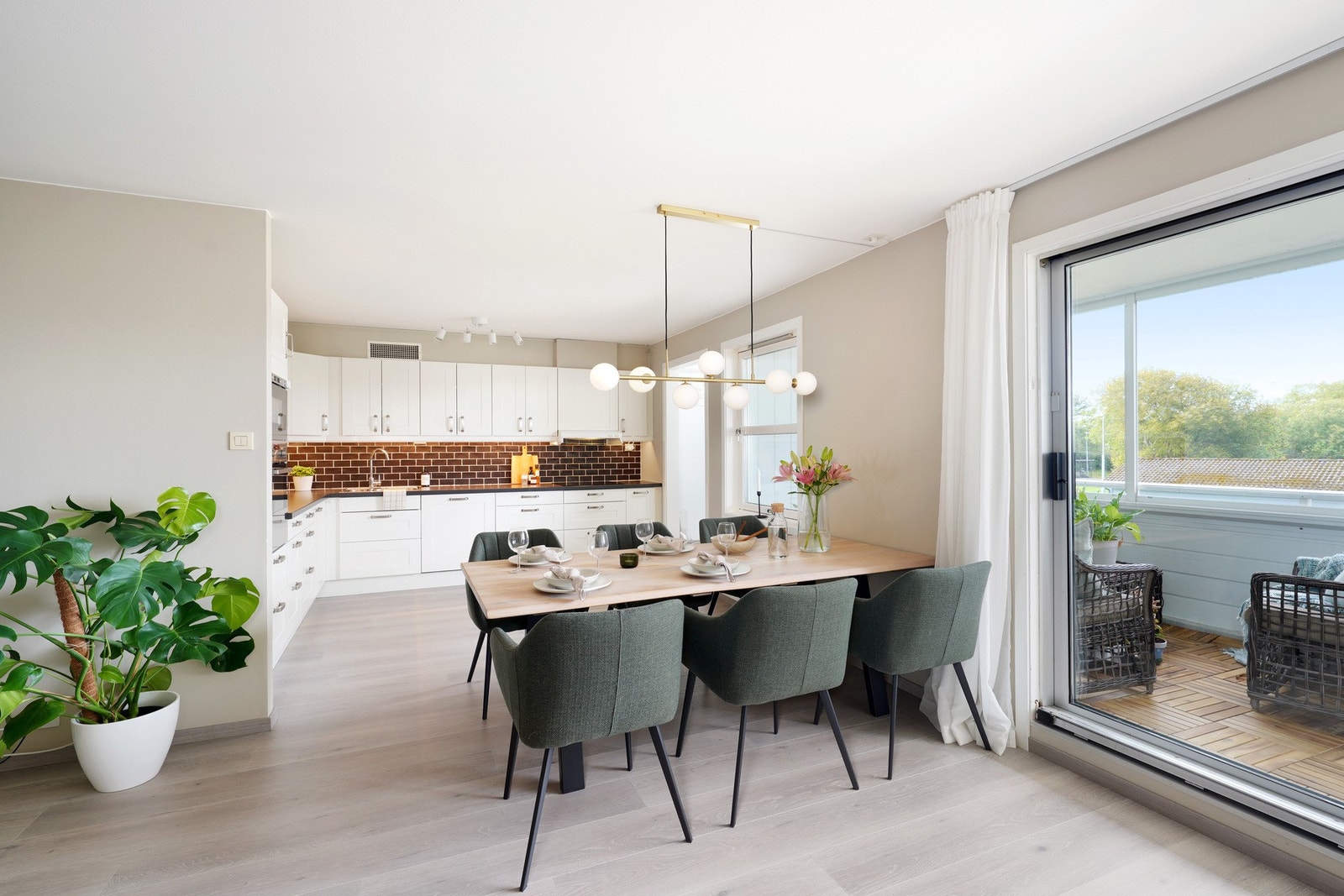 Det er utgang til den innglassede balkongen fra spisestuen/stuen Galleribilde