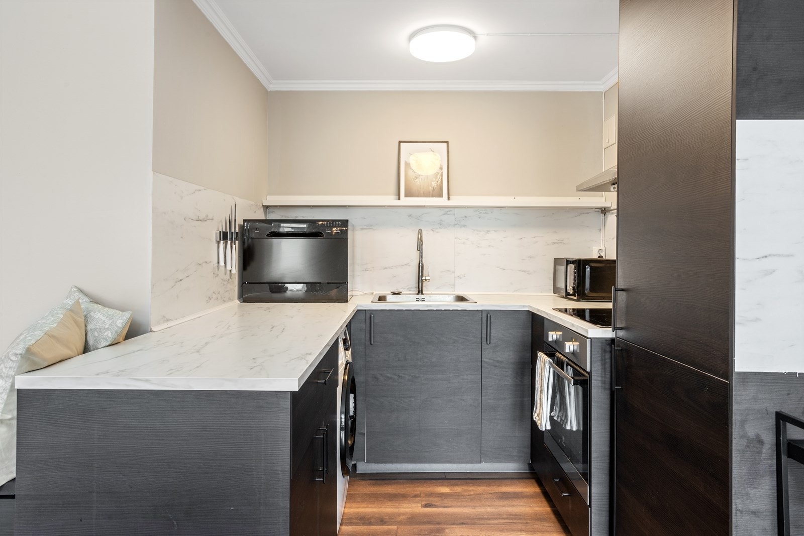 Moderne og stilrent kjøkken fra 2022 som har innredning med glatte fronter og benkeplate i høytrykkslaminat med nedfelt oppvaskkum. Galleribilde