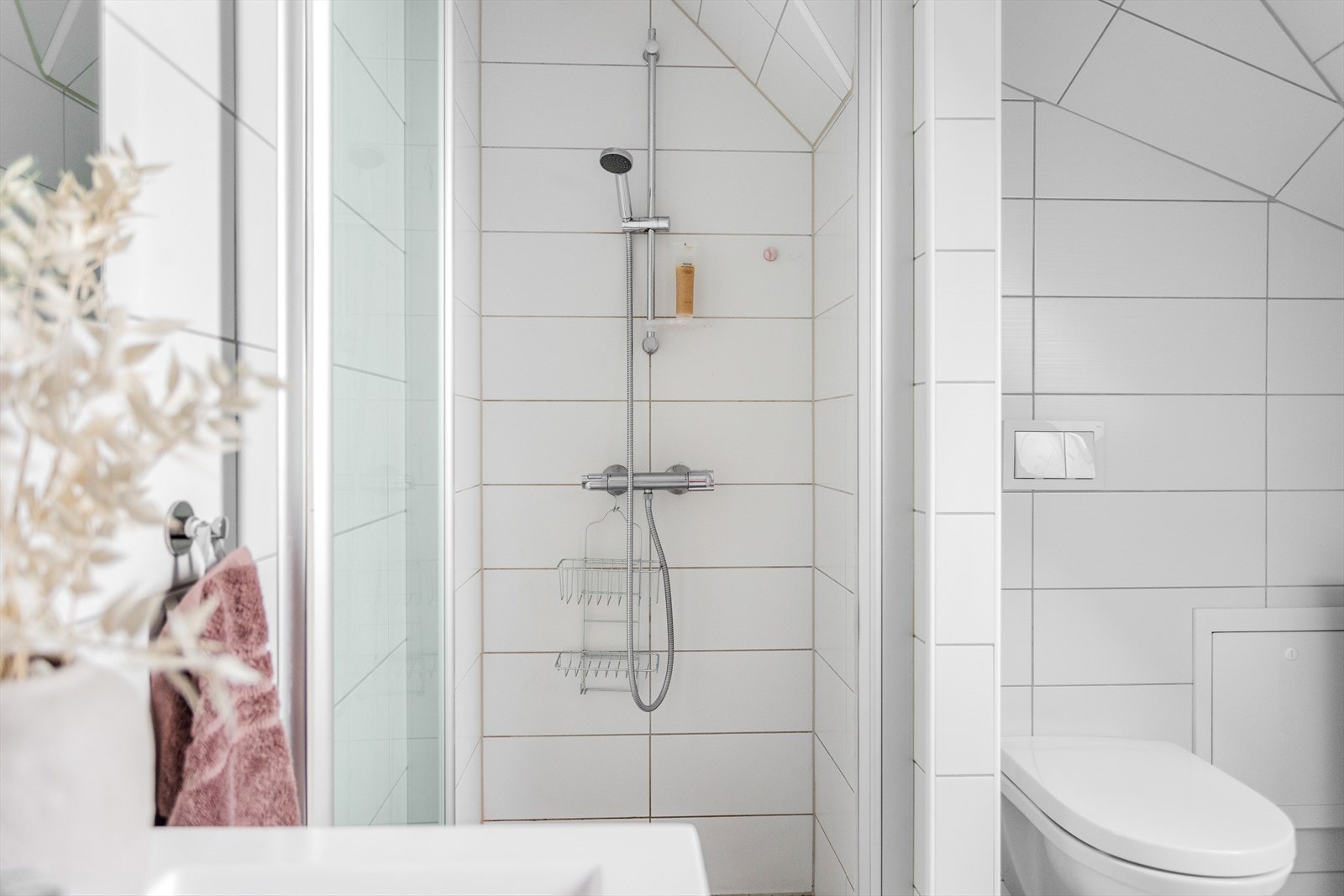 Badet inneholder vegghengt toalett, servantskap, opplegg for vaskemaskin, innsvingbar dusjdør og fordelerskap. Galleribilde