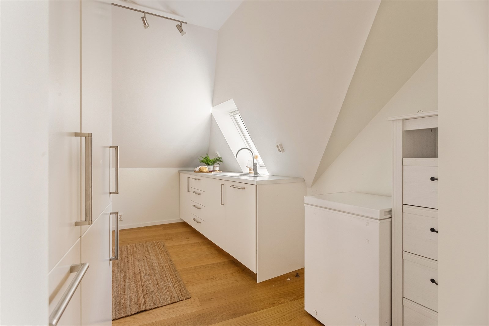 Kjøkkenet finner du midt i boligen og er av lyse slette fronter og laminat benkeplate. Av integrerte hvitevarer er det stekeovn, induksjonsplatetopp, oppvaskmaskin, kombiskap (kjøl/frys) og ventilator. Galleribilde
