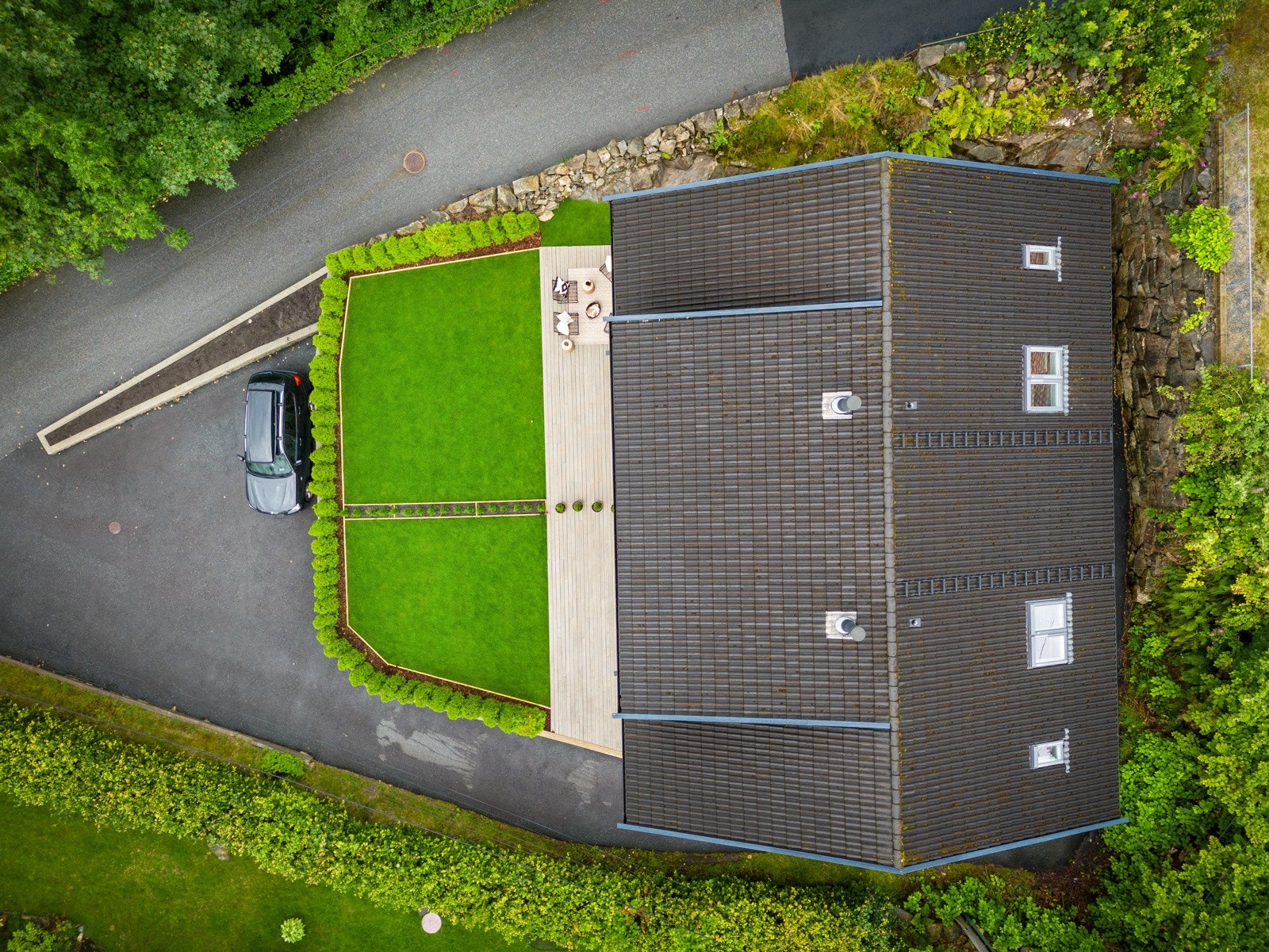 Felles parkering på andre siden av hagen hvor bilen står Galleribilde