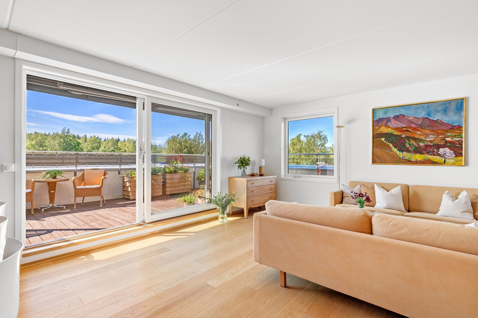 Store vindusflater gir mye naturlig lys til både kjøkken og stue Galleribilde