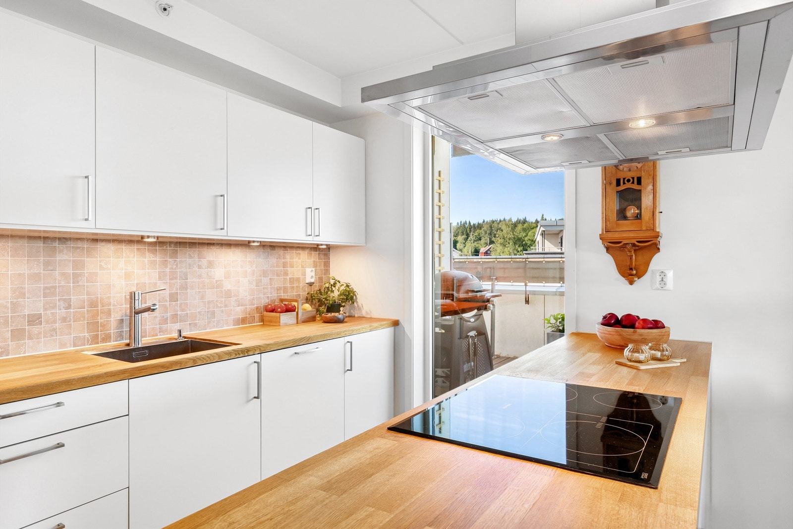 Kjøkkeninnredning med slette fronter og benkeplate i tre Galleribilde