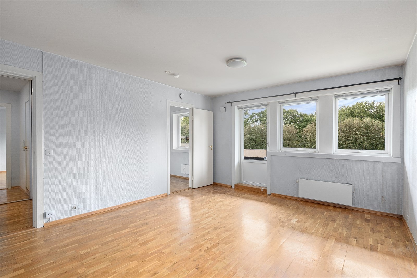 Overblikk over stue med inngan til kjøkken i senter av bildet. Galleribilde