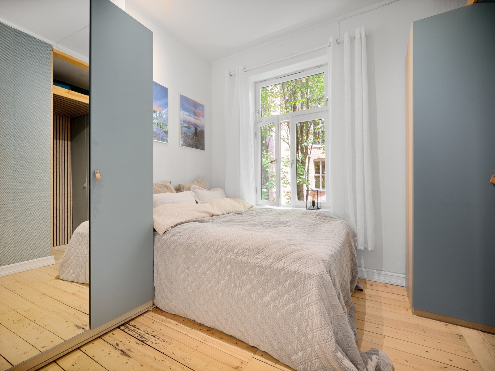 Soverom med malte flater i et lyst fargevalg samt en kontrastvegg med lekker tapet. Galleribilde