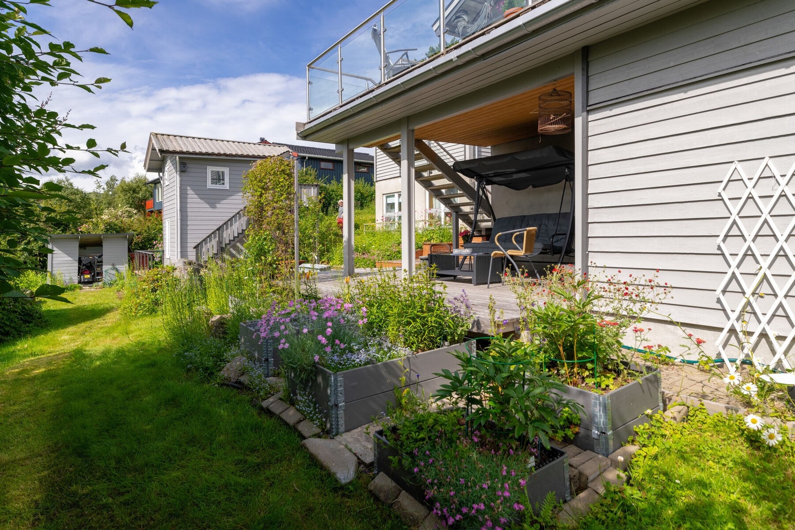 Den frodige hagen består av plen, busker og diverse beplantning. Galleribilde
