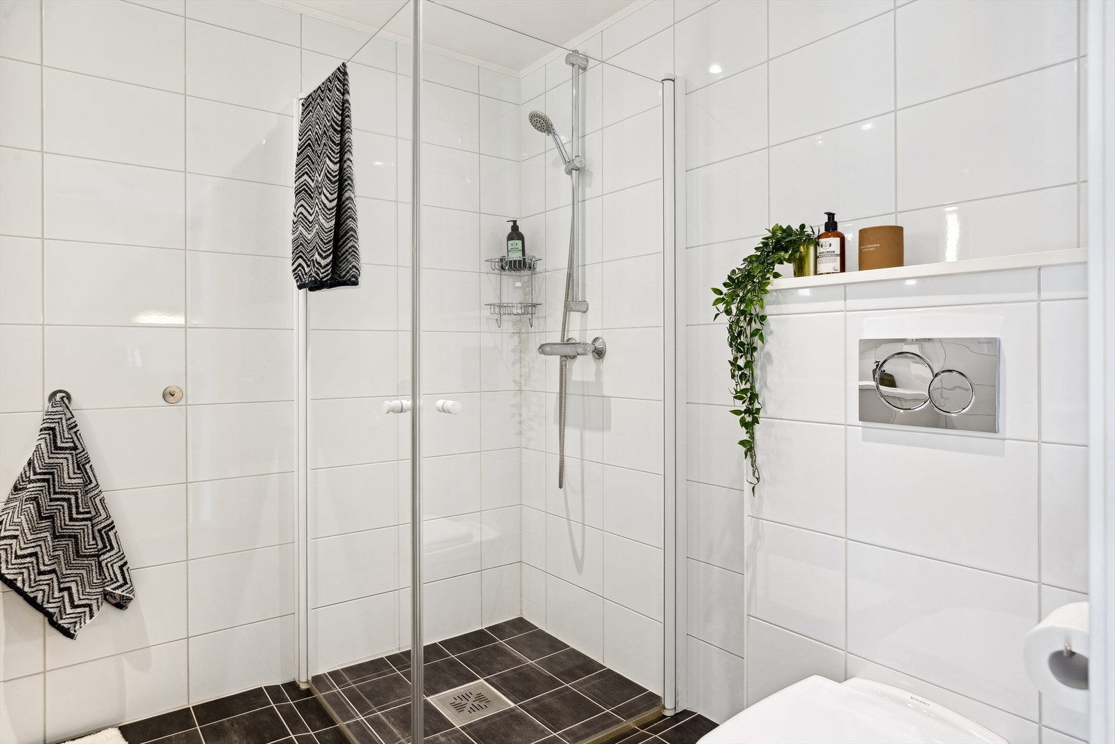 Badet har blant annet vegghengt toalett, gulvvarme, dusjhjørne og opplegg til vaskemaskin. Galleribilde