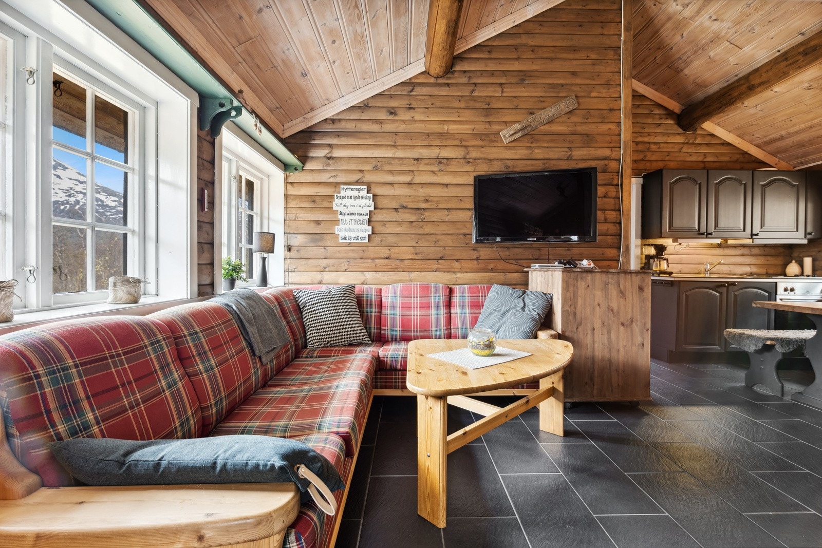 Stuen har store vinduer, noe som gir et flott gjennomlys, og det er også ekstra takhøyde. Galleribilde