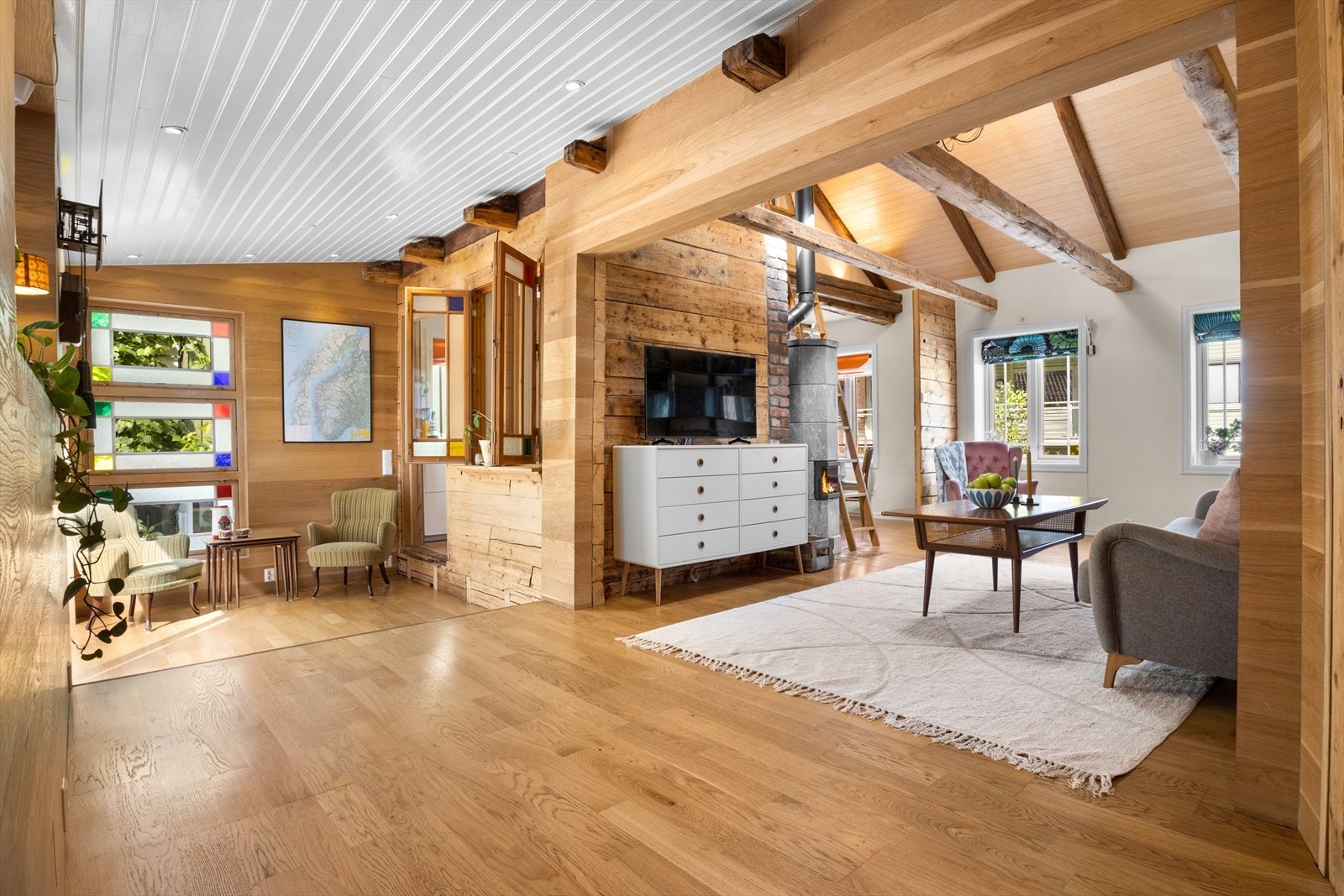 I stuen finner du nesten 200 år gamle bærebjelker, vegger av eik og ett vakkert ubehandlet osppanel i gavelvegg og tak Galleribilde