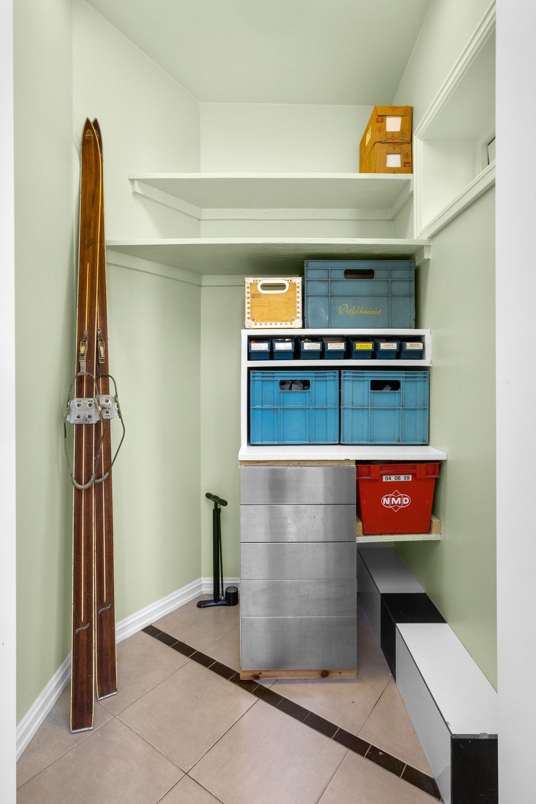 Bod i hjørnet av soverommet i det hvite uthuset med utvendig dør fra hagen. Galleribilde