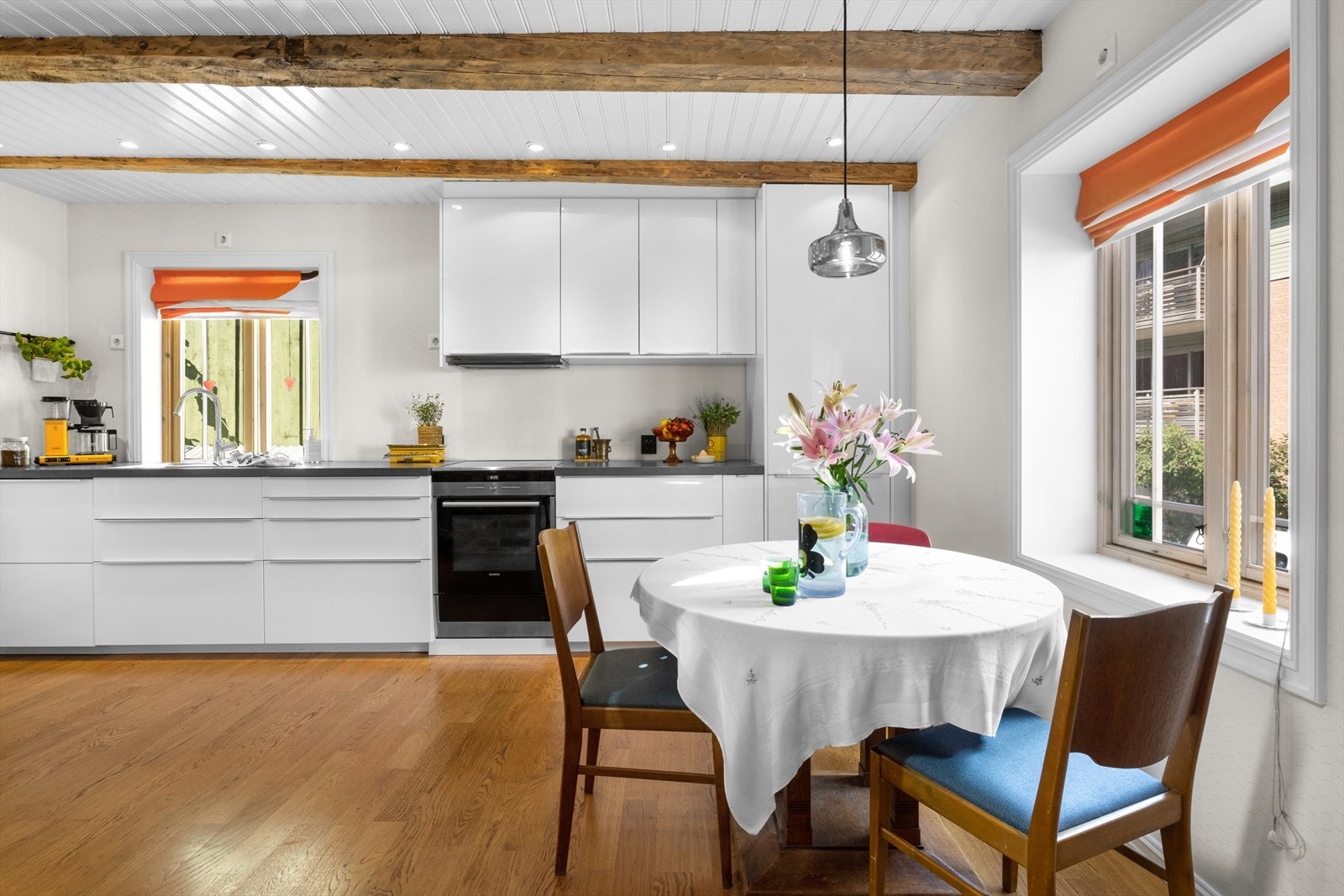 Kjøkken med tidløse høyglansfronter og lang benkeplate med god plass for å tilberede mat. Kjøkkenet får lys fra tre sider. Galleribilde