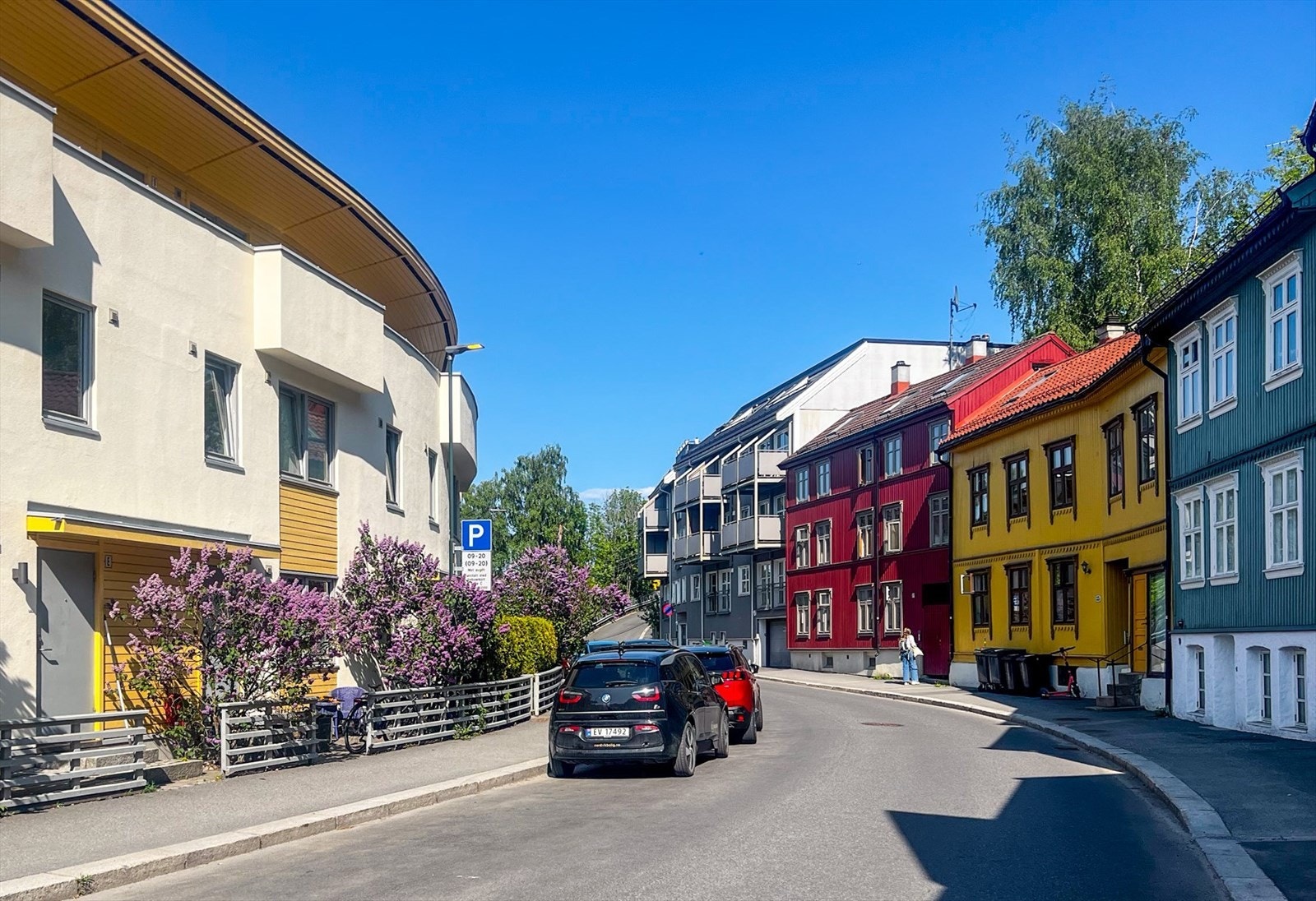 Uten for er Konows gate på sitt vakreste med koselig bebyggelse, frodige forhager, syrintrær og brede fortau. Galleribilde