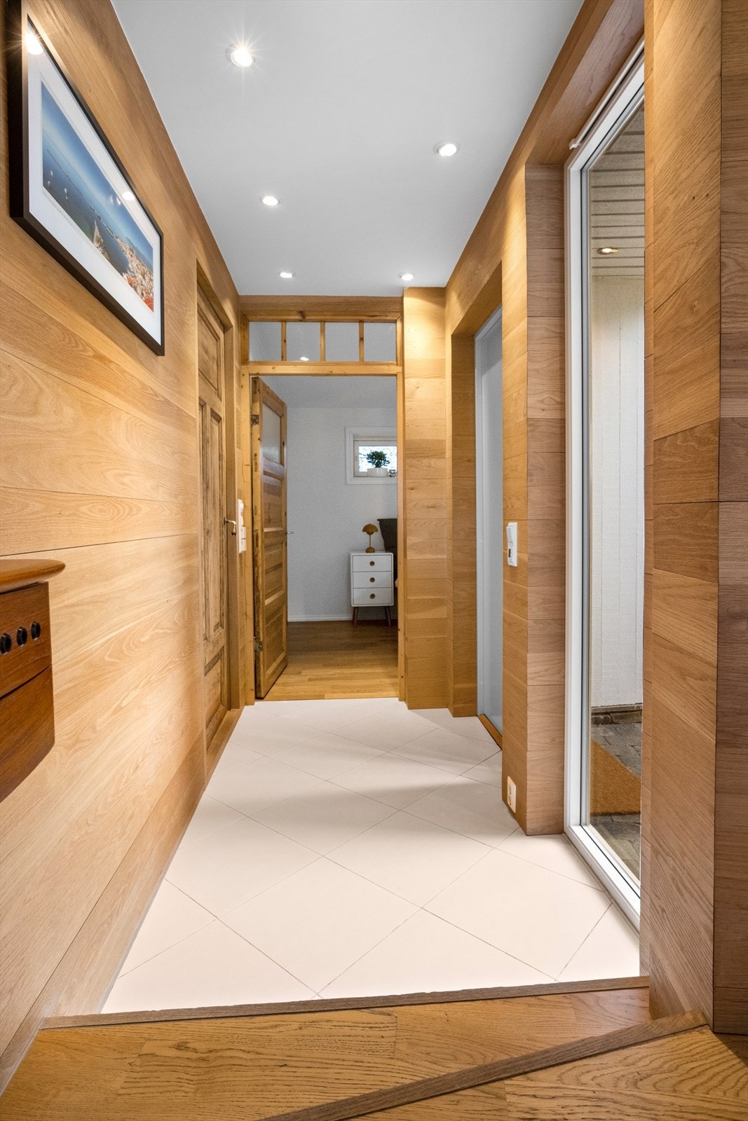 Entréen har flislagt gulv med varme og eikepanel med 30 mm tykke planker. Galleribilde