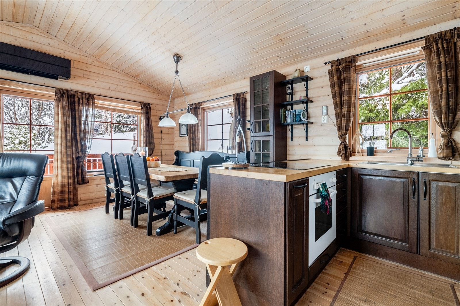 En liten halvøy deler fint av mot kjøkkenet hvor det er innredning med profilerte fronter og benkeplate av heltre. Galleribilde