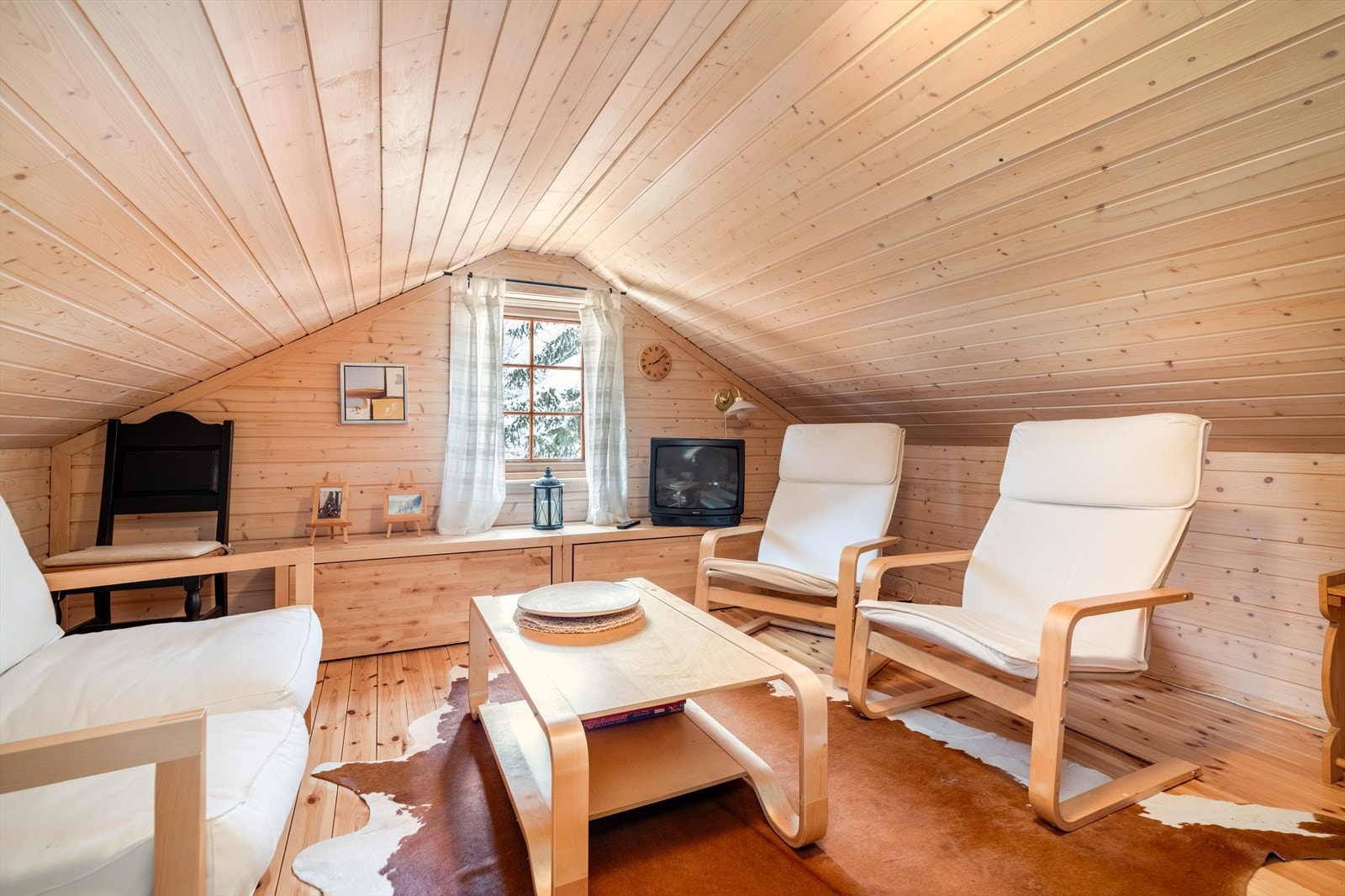 Fra stuen er det adkomst til loftet, hvor det er innredet en hyggelig hems med møblement og ekstra sengeplasser. Galleribilde