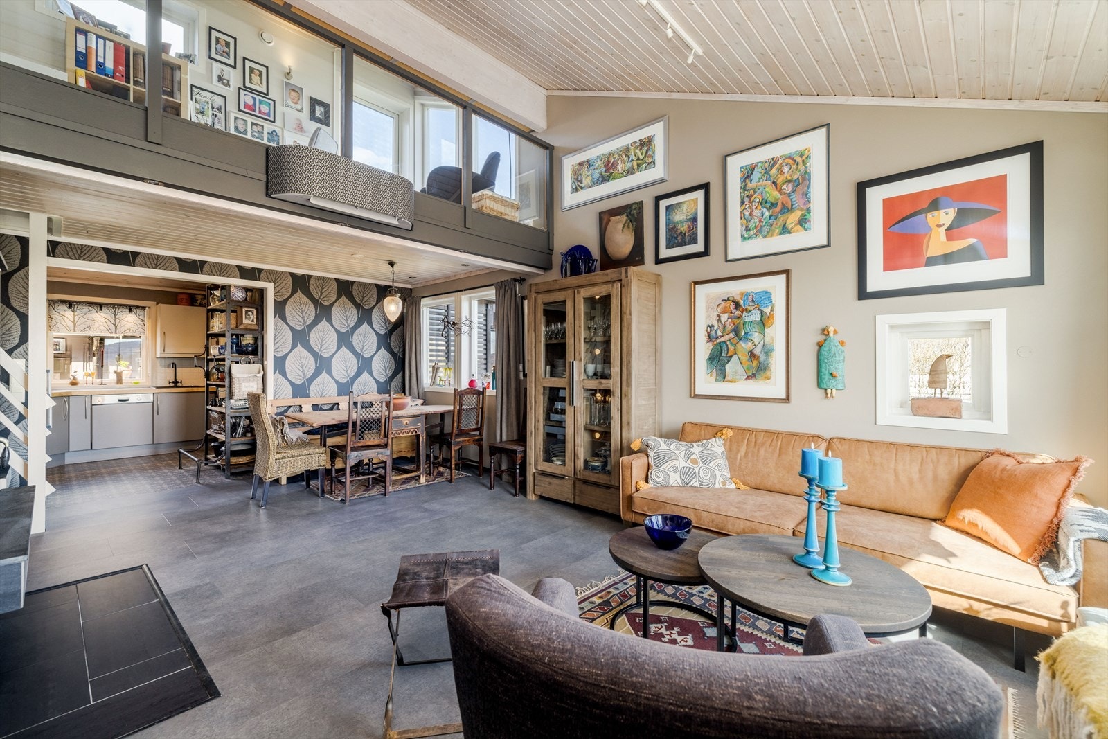 Skråtak med god takhøyde mot overliggende hems med loftstue, som har glassrekkverk mot stuen og gir ekstra lys til rommet og en annerledes god og luftig atmosfære. Galleribilde