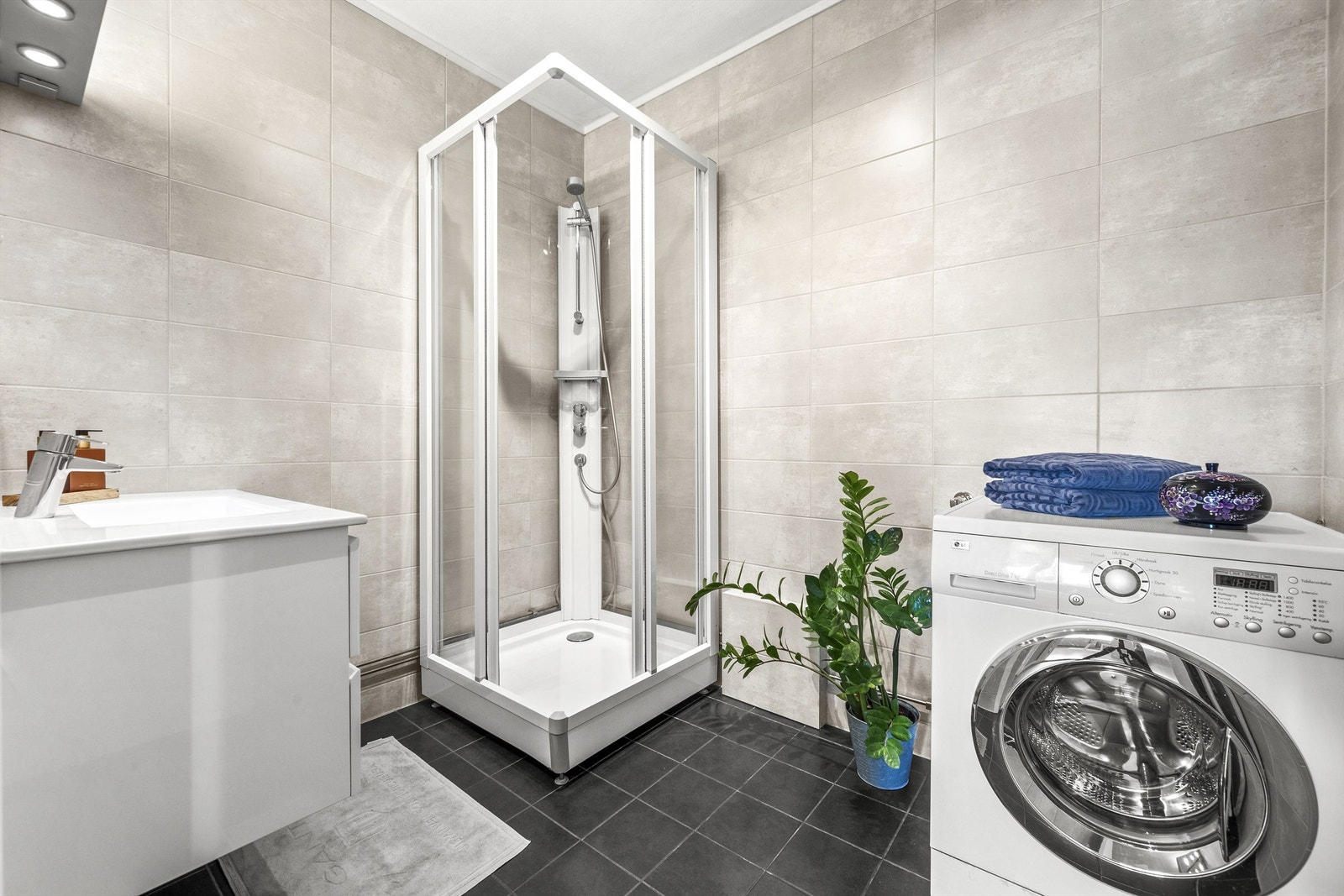 Lekkert baderom belagt med fliser på gulv og vegger Galleribilde