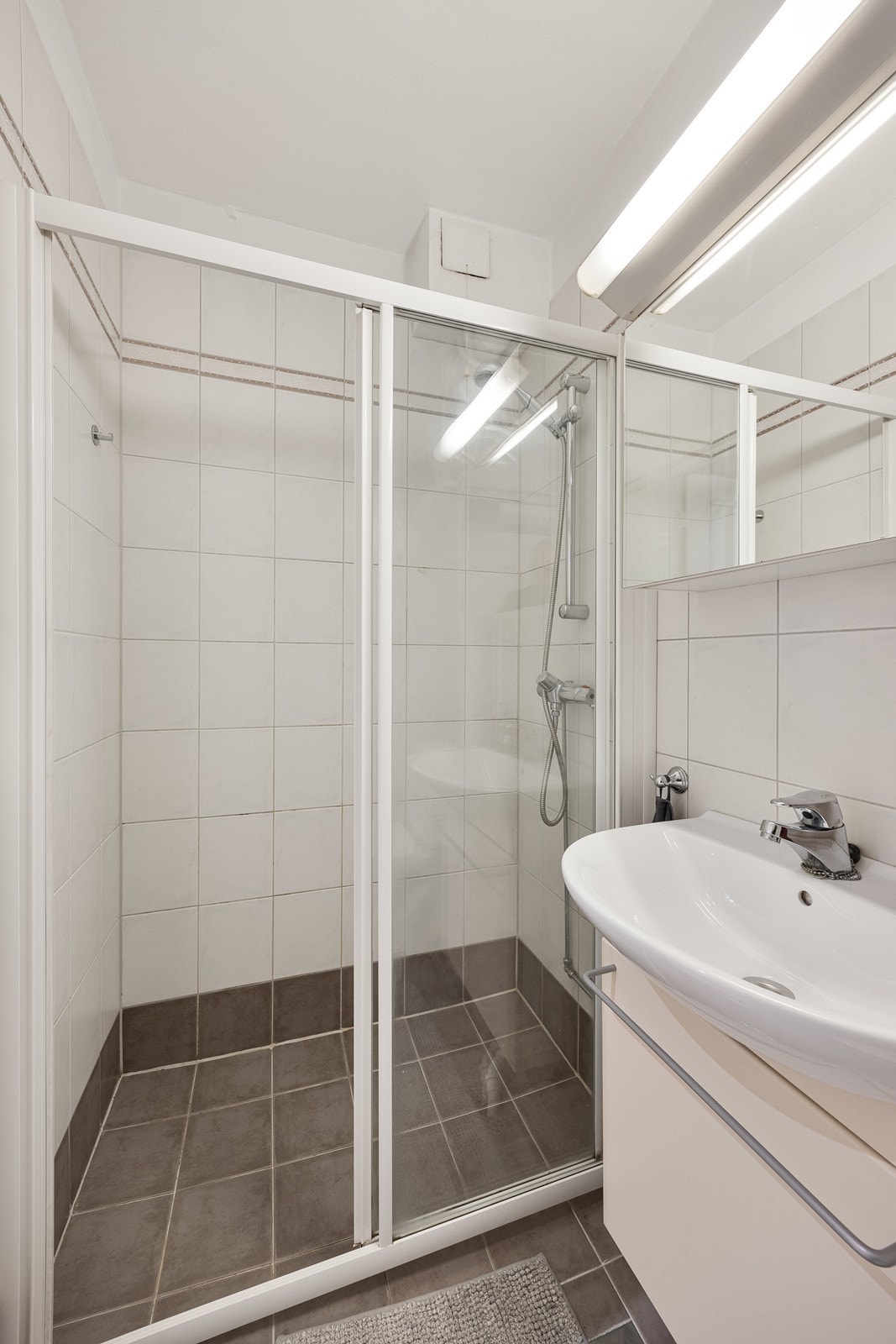 Videre er det toalett og dusjhjørne med skyvedør. Galleribilde