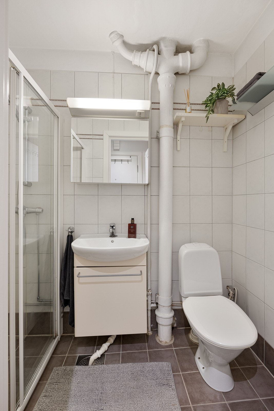 Badet har heldekkende servant over skapseksjon og speil med belysning. Galleribilde