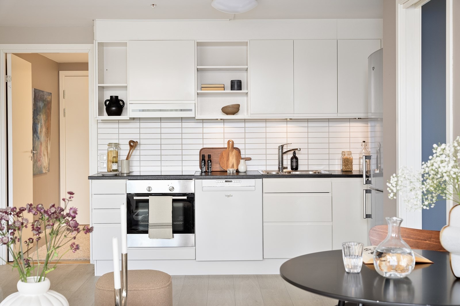 Pen, klassisk kjøkkeninnredning med glatte fronter på over- og underskap, samt laminert benkeplate. Kitchenboard i benkerygg og lys under overskap. Galleribilde