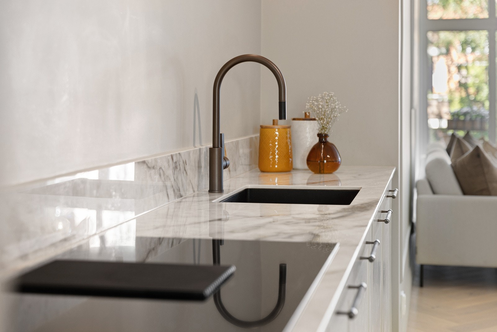 Nedfelt oppvaskkum med kjøkkenarmatur med uttrekk og flott keramisk benkeplate. Galleribilde