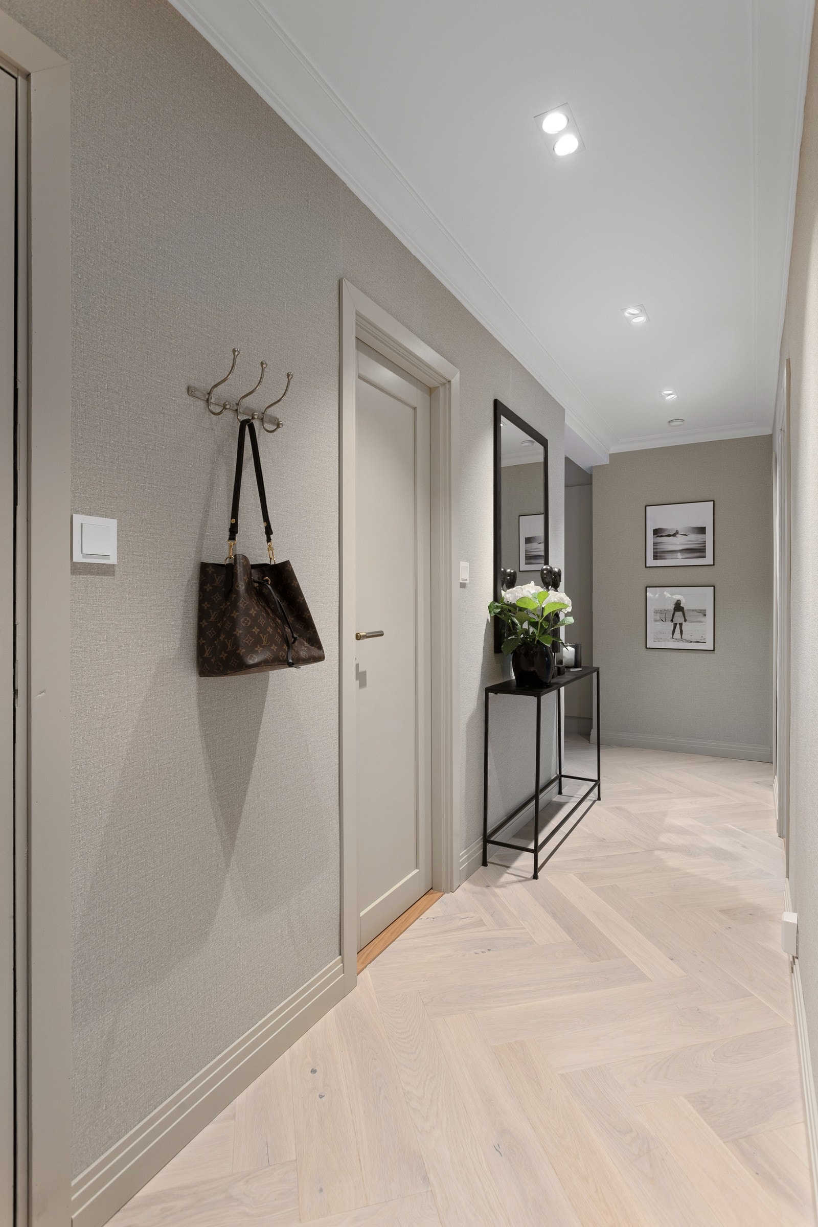 I entreen er det plass til sko og yttertøy. Ytterligere lagringsplass finnes også i omkledningsrommet, samt bod på loft og i kjeller. Legg merke til den eksklusive tapeten fra Elitis på overflatene. Galleribilde