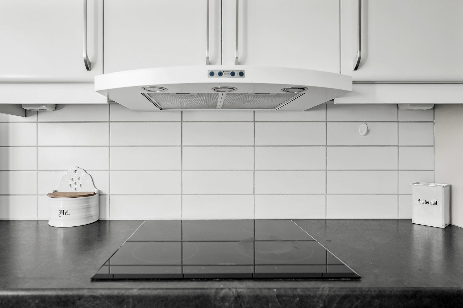 Ventilator med kullfilter plassert i overskap over platetopp. Galleribilde