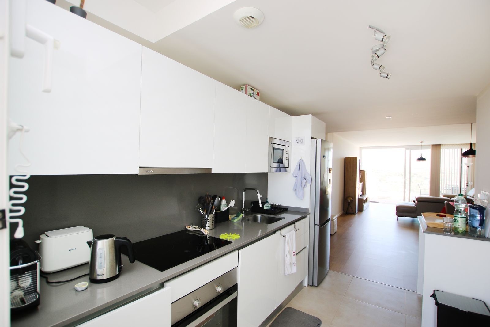 Moderne kjøkken med integrerte hvitevarer og god plass til matlaging. Galleribilde