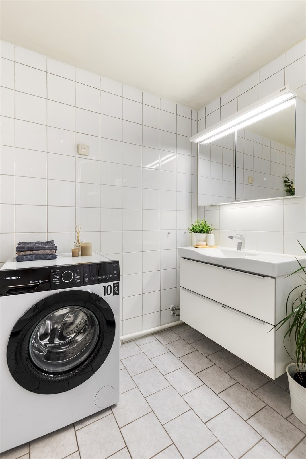 Rommet har innredning med nedfelt servant, dusjkabinett og opplegg for vaskemaskin. Galleribilde