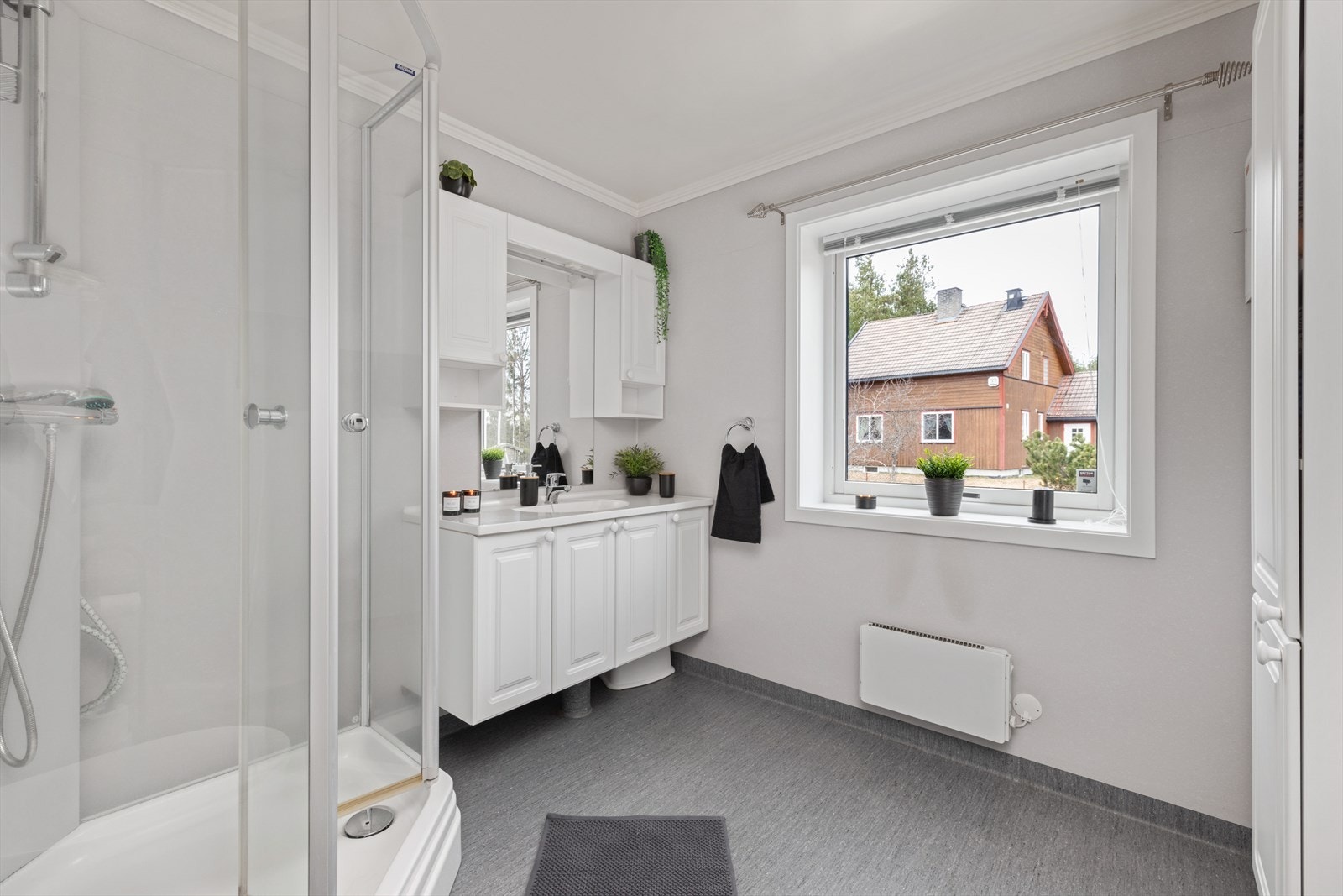 Fint bad i 1.etasje innredet med servant på innredning, dusjkabinett og vegghengt toalett. Galleribilde