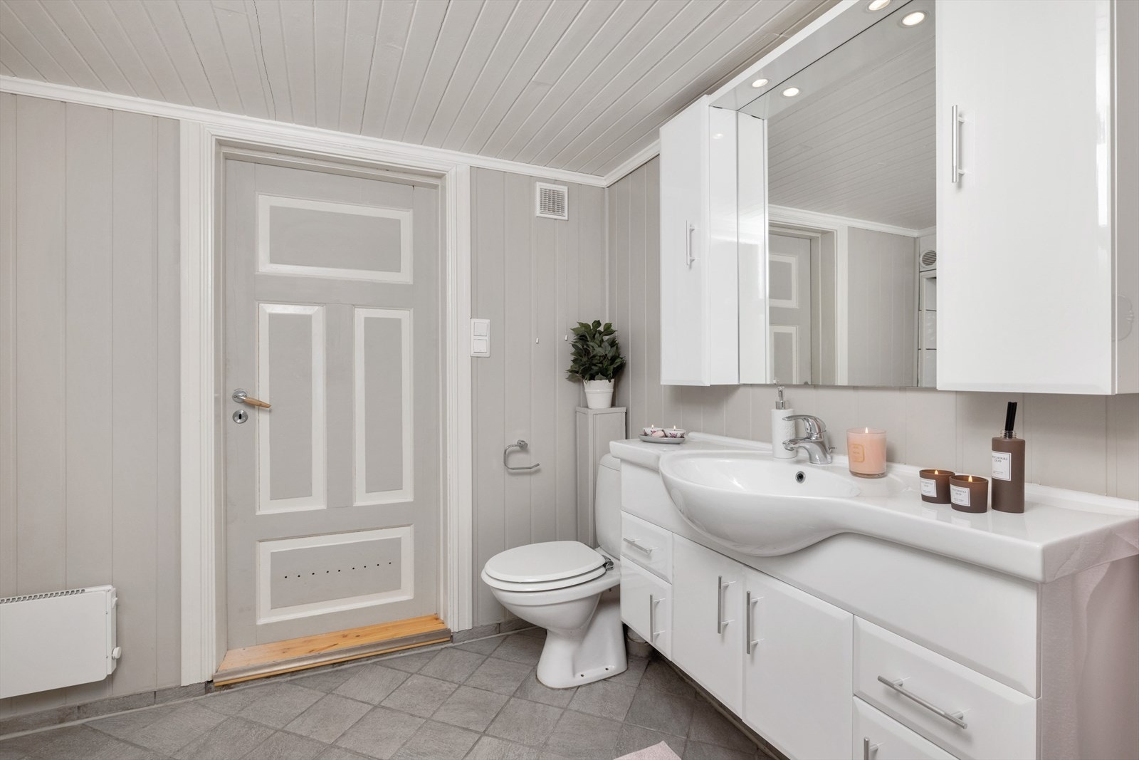 Badet i kjelleren er innredet med servant på innredning, toalett og dusjhjørne. Galleribilde