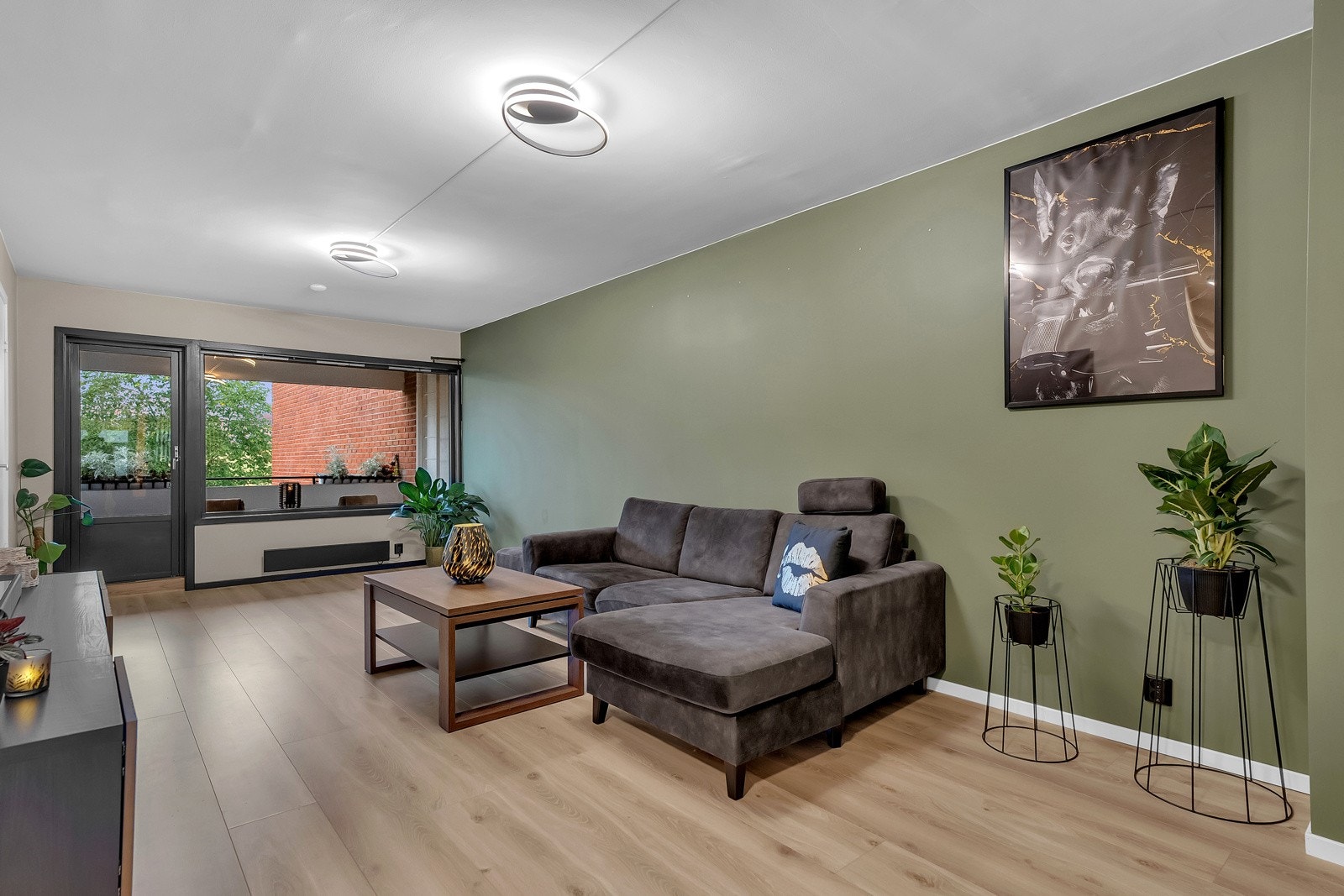 Vinduene og terrassedøren har svarte detaljer og en spilevegg mellom kjøkkenet og stuen er også malt svart, dette gir en lekker helhet. De store vinduene slipper rikelig med naturlig lys inn i rommet. Galleribilde