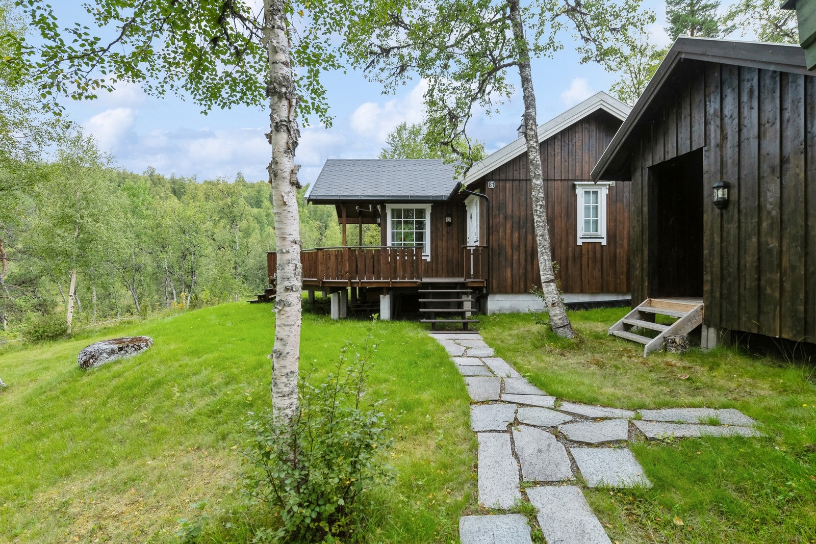 Det er skiferlagt adkomst til hytte, utebod og anneks. Galleribilde