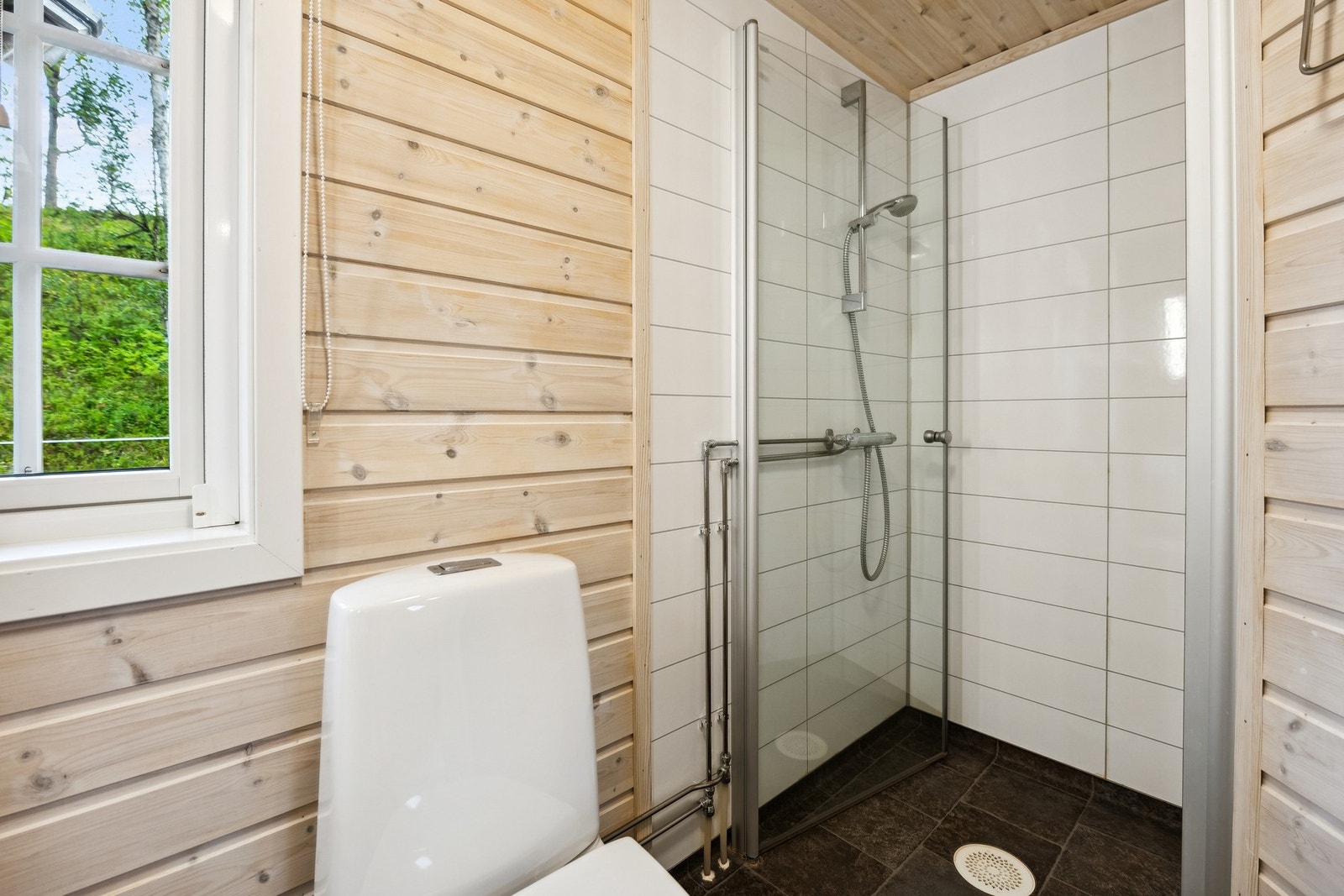 Dusjhjørnet er kledd med våtromsplater i flisimitasjon, og rommet har mekanisk avtrekk. Galleribilde