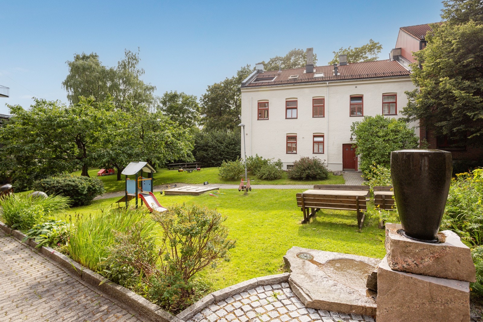 Fellesarealer opparbeidet med asfalterte internveier, lekeapparater, plenarealer og diverse beplantning. Hyggelige sittegrupper. Galleribilde