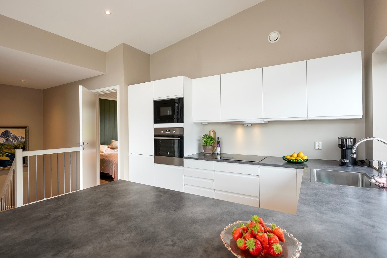 Kjøkkenet har en stilren innredning plassert i U-form, med barløsning mot stuen og alle hvitevarer integrert Galleribilde