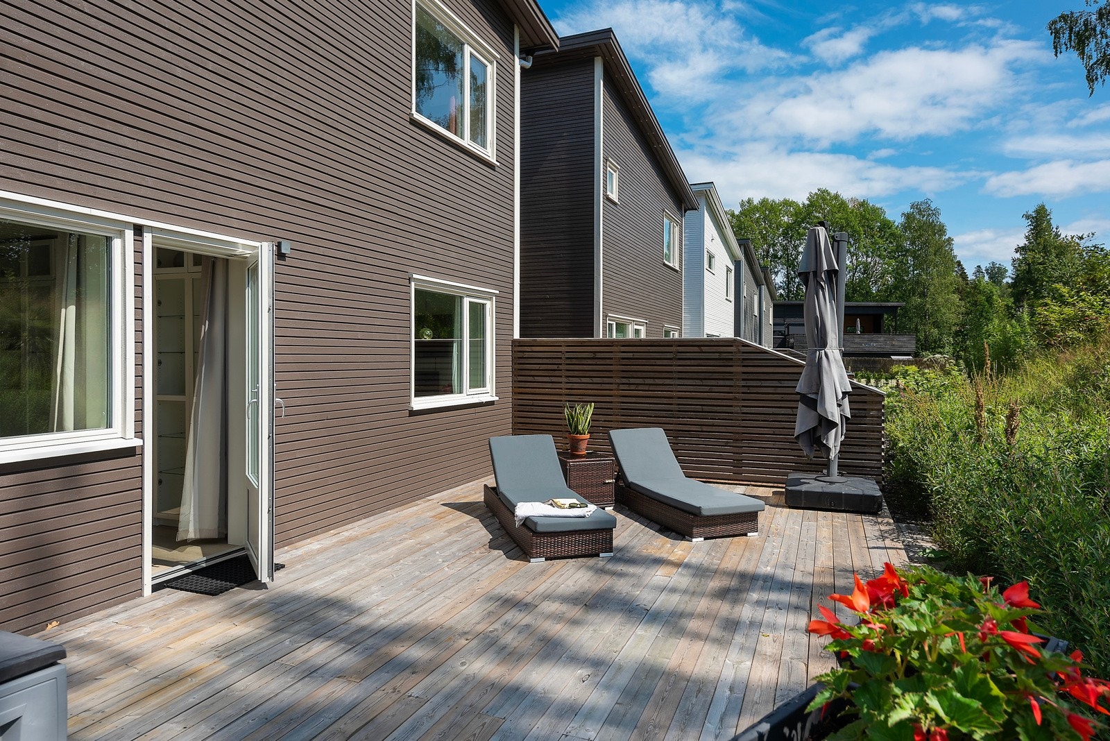 Den sydvendte terrassen ligger usjenert mot grønne landbruksområder og har adkomst fra tv-stuen i første etasje Galleribilde