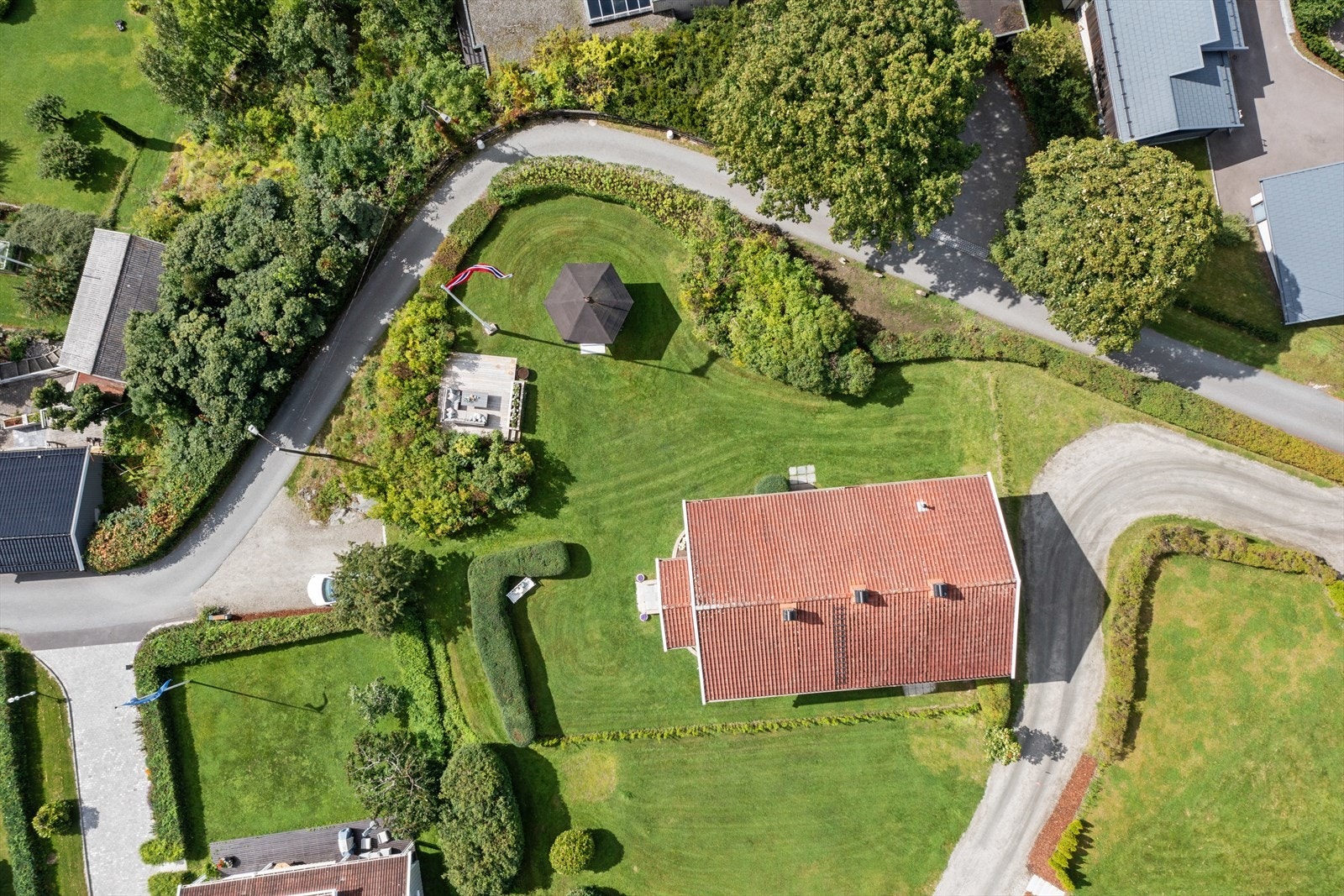 Velstelt og parkmessig anlegt hage med flott plen omkranset av hekk og prydbusker som gir et usjenert og privat uteområde Galleribilde