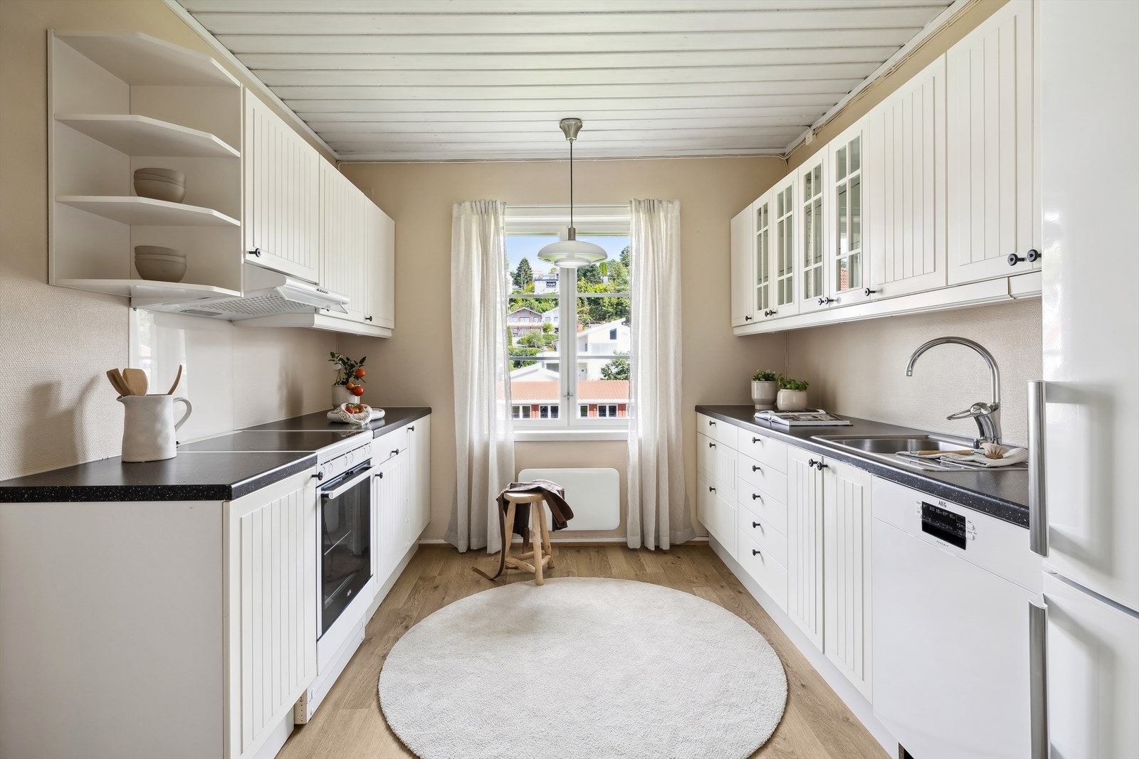 Kjøkken fra 2007 med hvit profilert kjøkkeninnredning og laminat benkeplate. Galleribilde